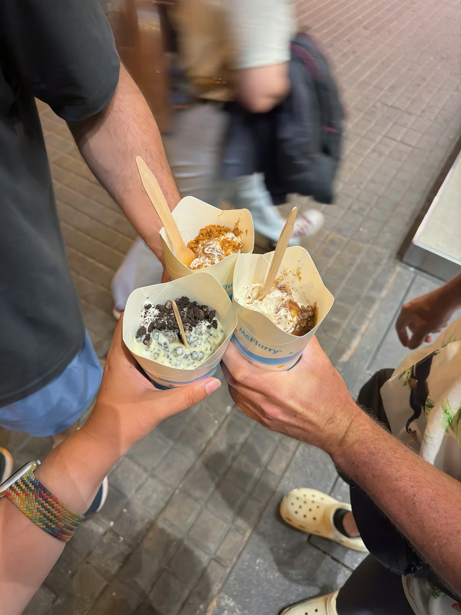 Three McFlurry cups raised together in a toast at McDonald's in Barcelona, Spain.