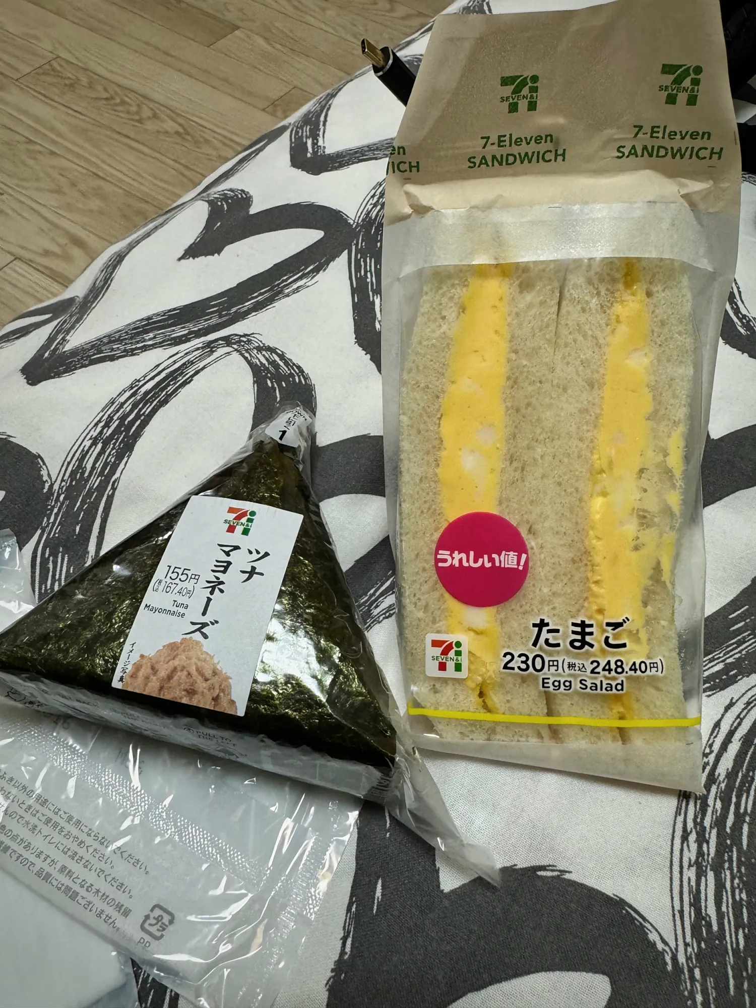 A 7-Eleven egg salad sandwich priced at 230 yen and a tuna mayonnaise onigiri, in Osaka.