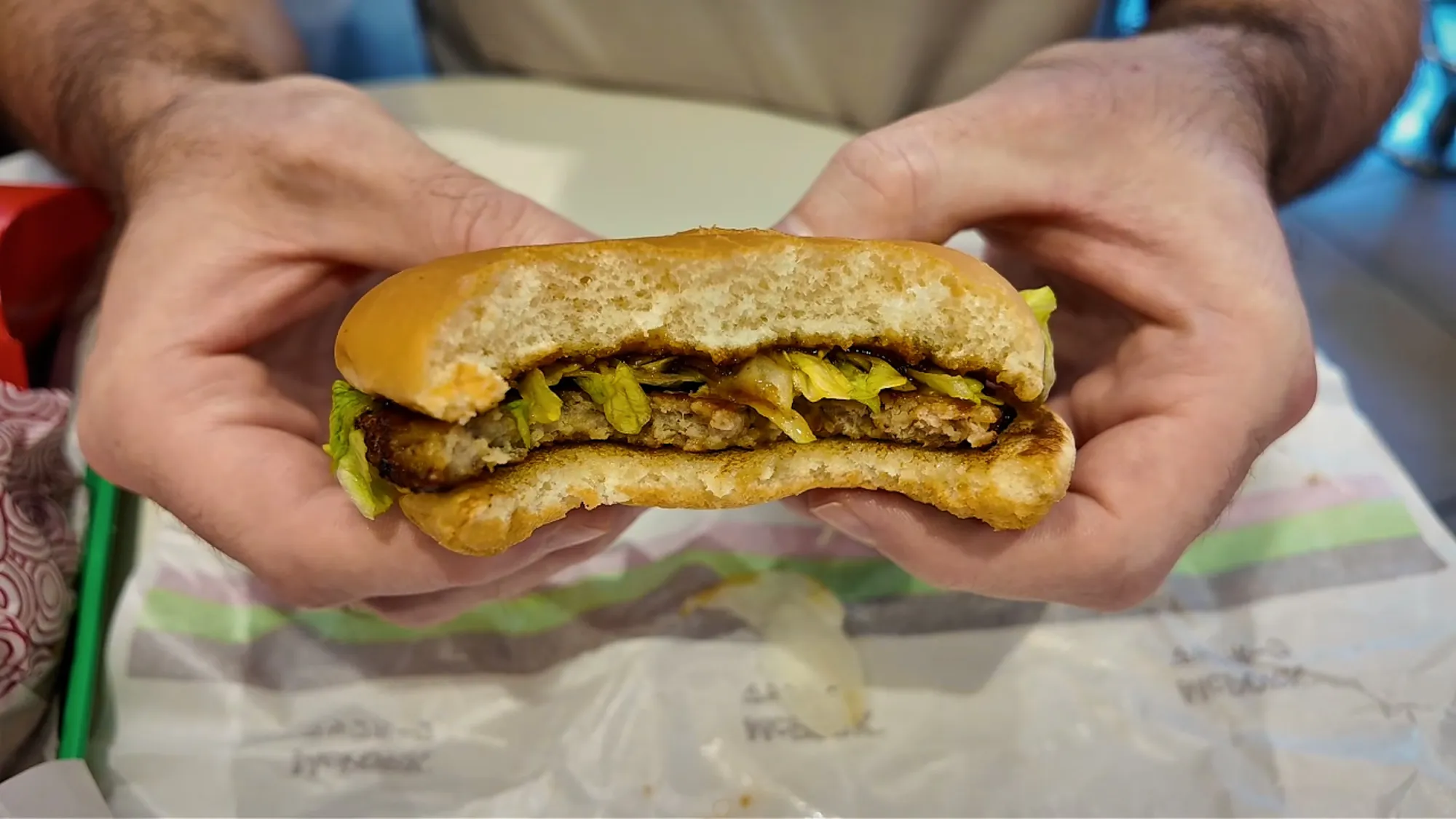 A bitten McPork at McDonald's in Japan, showing the thin pork patty, lettuce, and teriyaki-style sauce in a plain bun.