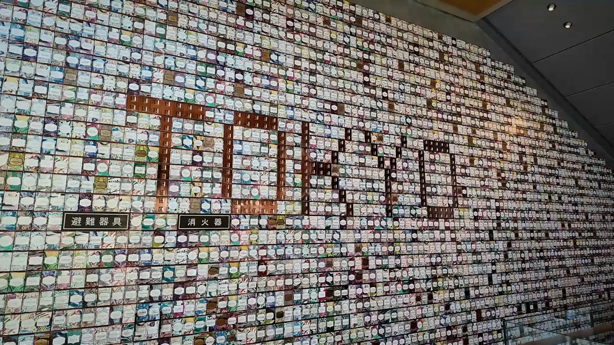 A huge wall of small coffee cards arranged to spell out TOKYO inside Starbucks Reserve Roastery Tokyo.