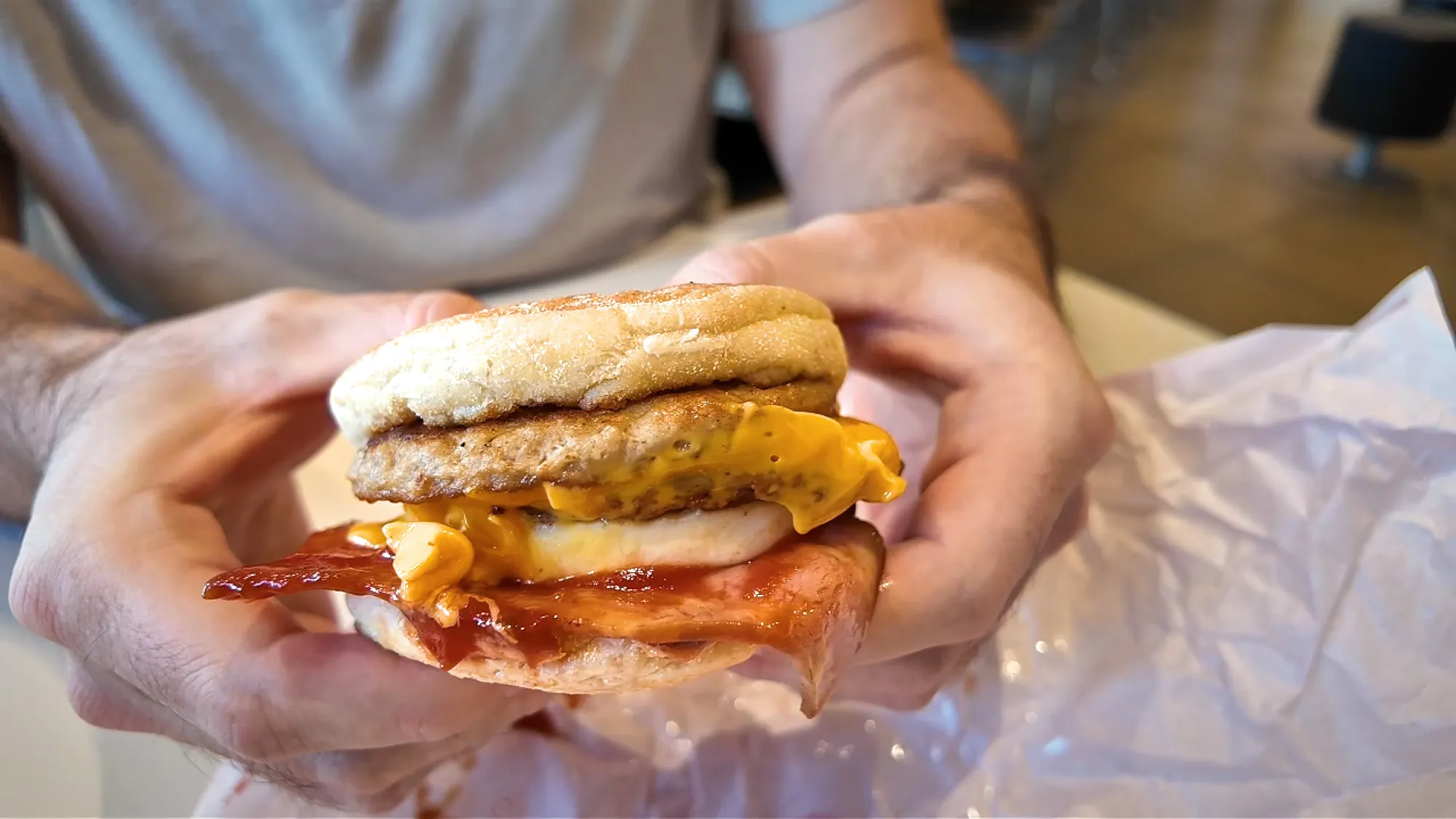 A Mega Muffin held open at McDonald's in Japan, showing the sausage patties, egg, cheese, and thin bacon in an English muffin.