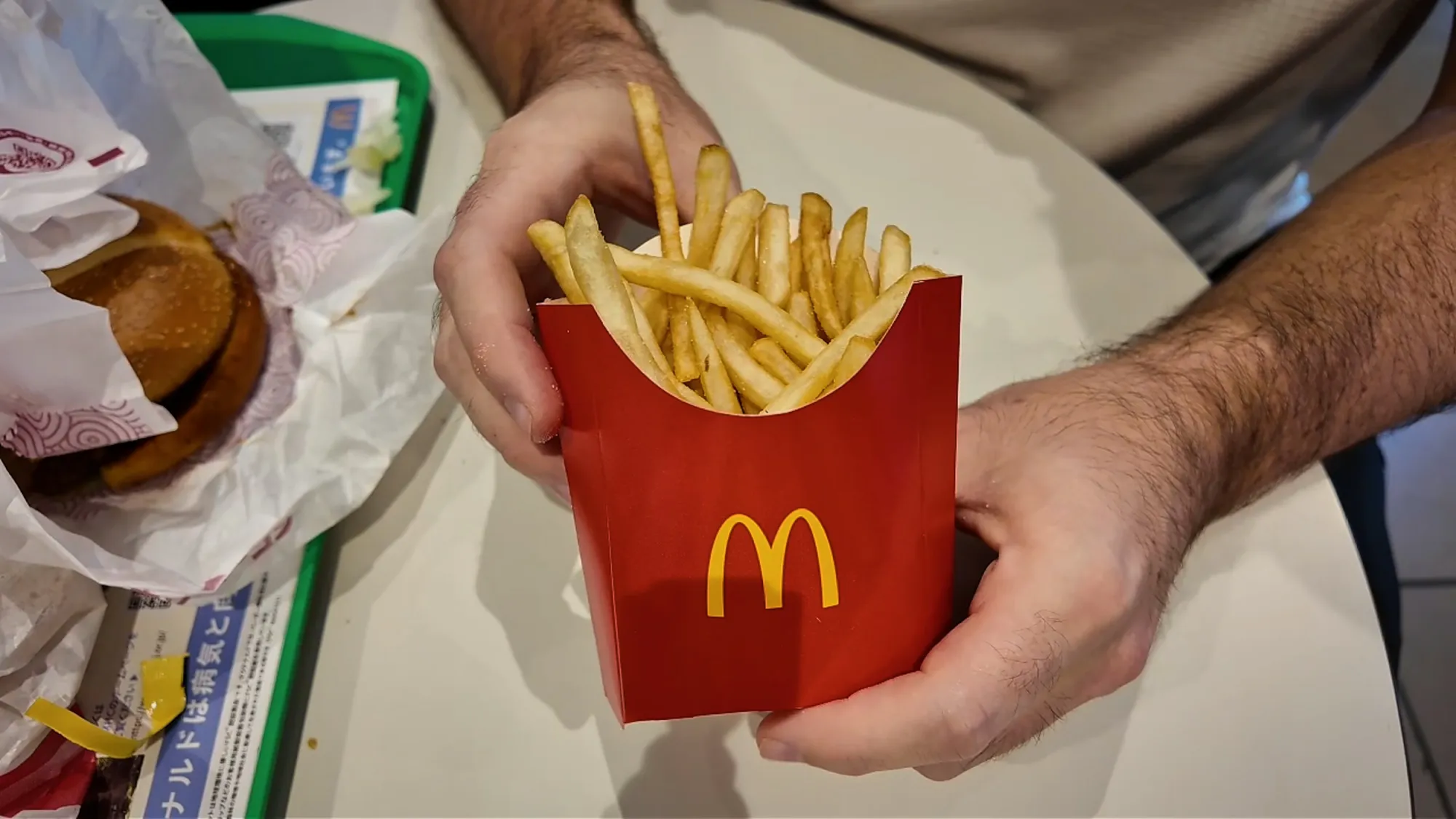 A red carton of McDonald's fries held up at a table in Tokyo.