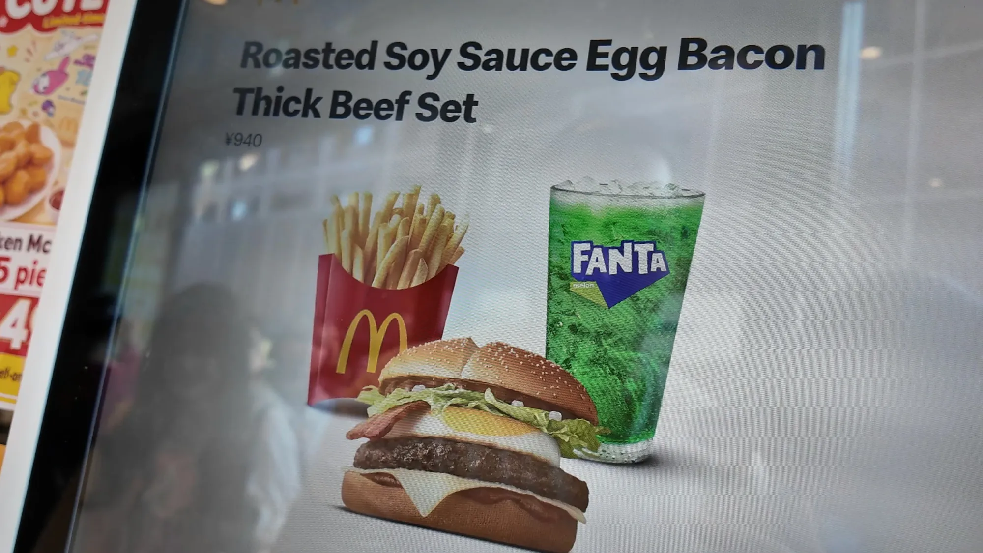 A menu screen at McDonald's in Shinjuku, Tokyo, showing the Samurai Mac set in English as the Roasted Soy Sauce Egg Bacon Thick Beef Set with fries and a Fanta Melon.