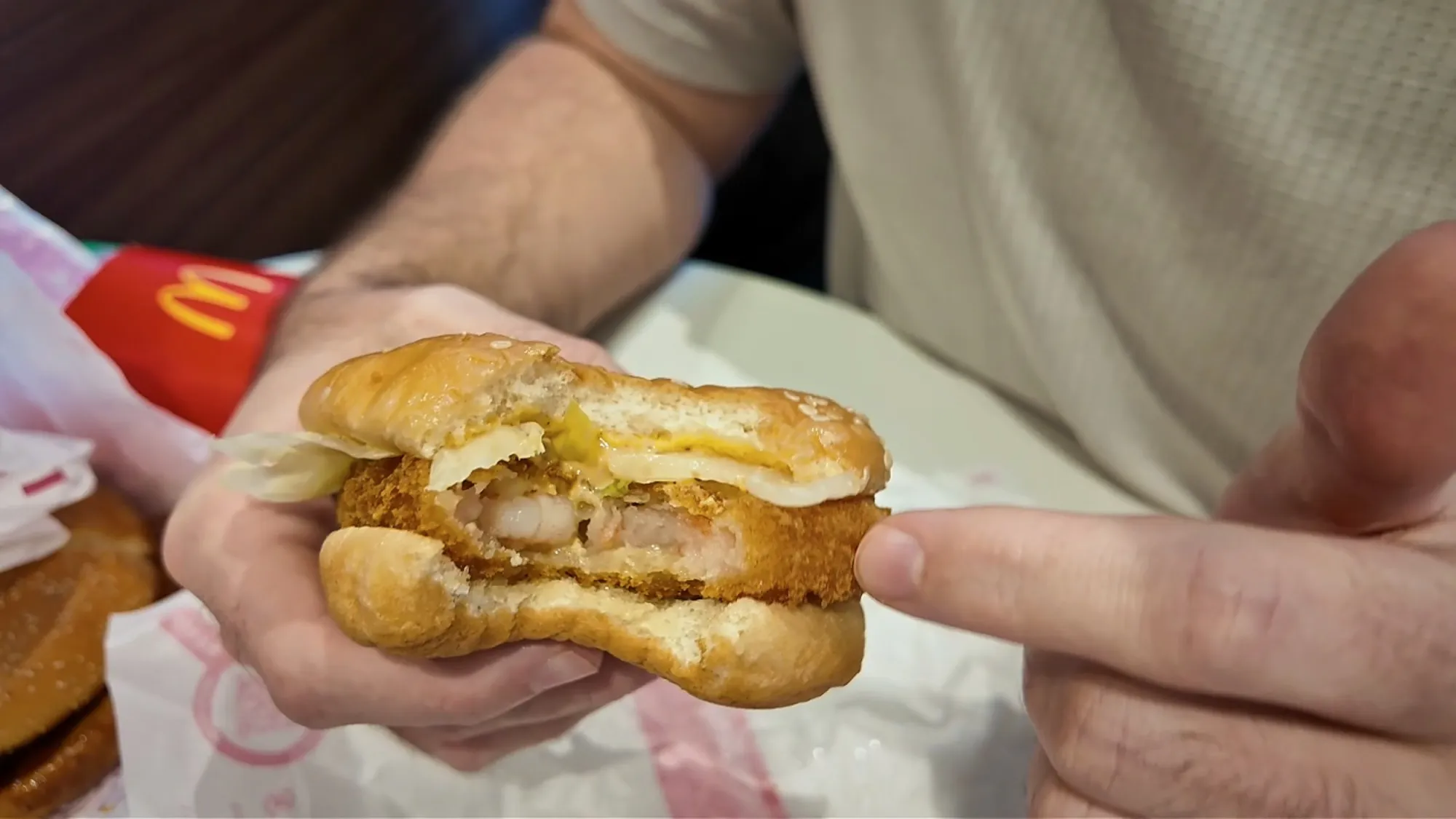 A bitten Ebi Filet-O at McDonald's in Japan, showing the whole shrimp inside the panko-fried patty.
