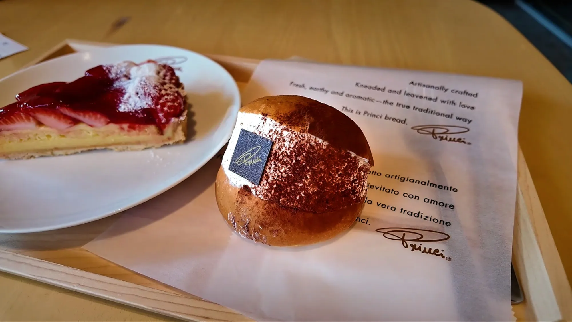 A slice of strawberry tart and a cream-filled maritozzo bun on a tray at Starbucks Reserve Roastery Tokyo.