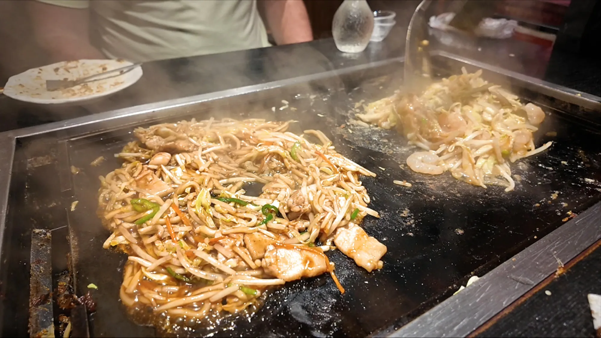 Pork yakisoba noodles and bean sprouts frying on the griddle at Osakaya in Tokyo