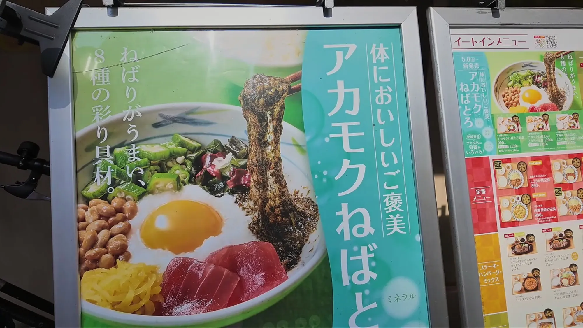 A poster outside Yayoiken in Tokyo advertising the Akamoku Nebatoro bowl with natto, okra, a raw egg, tuna, and sticky akamoku seaweed, next to the eat-in menu board.
