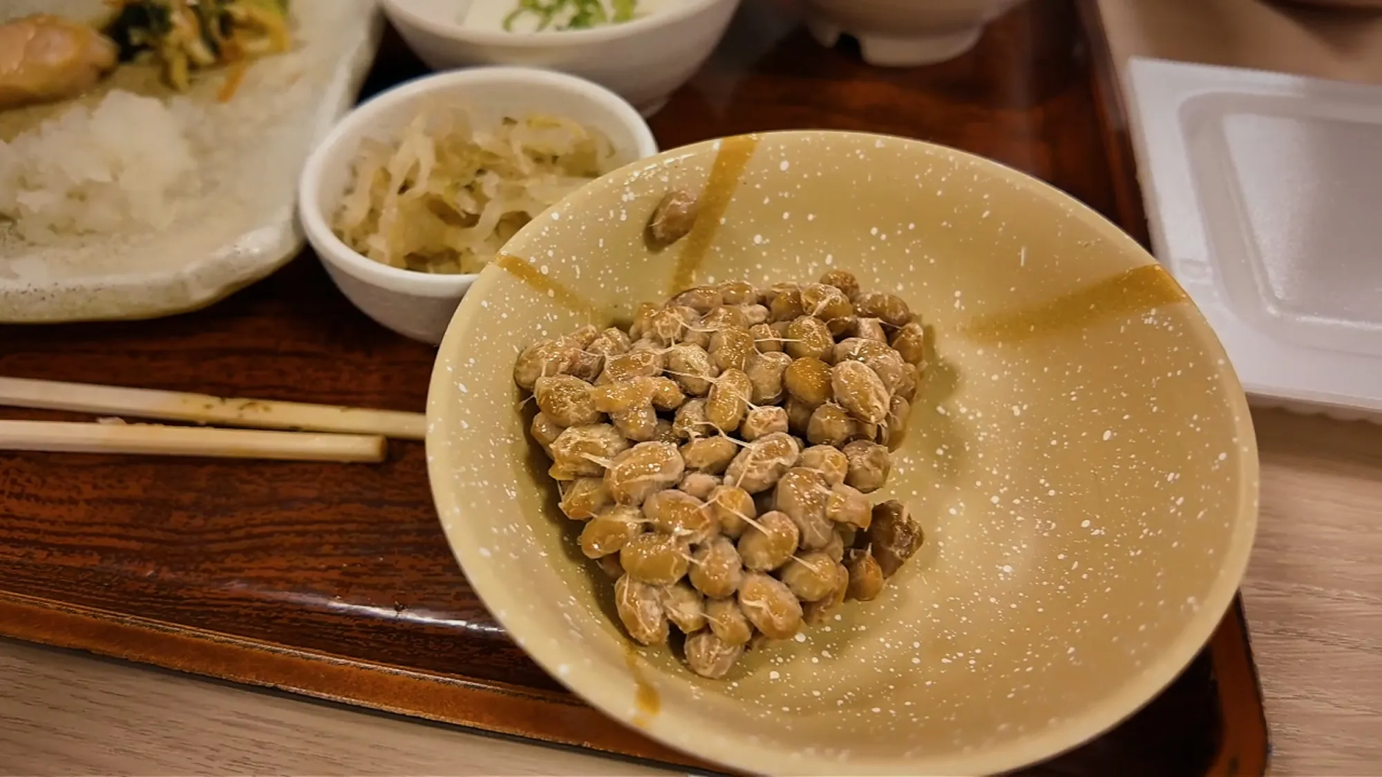 A bowl of sticky natto beans on a breakfast tray at Yayoiken in Tokyo