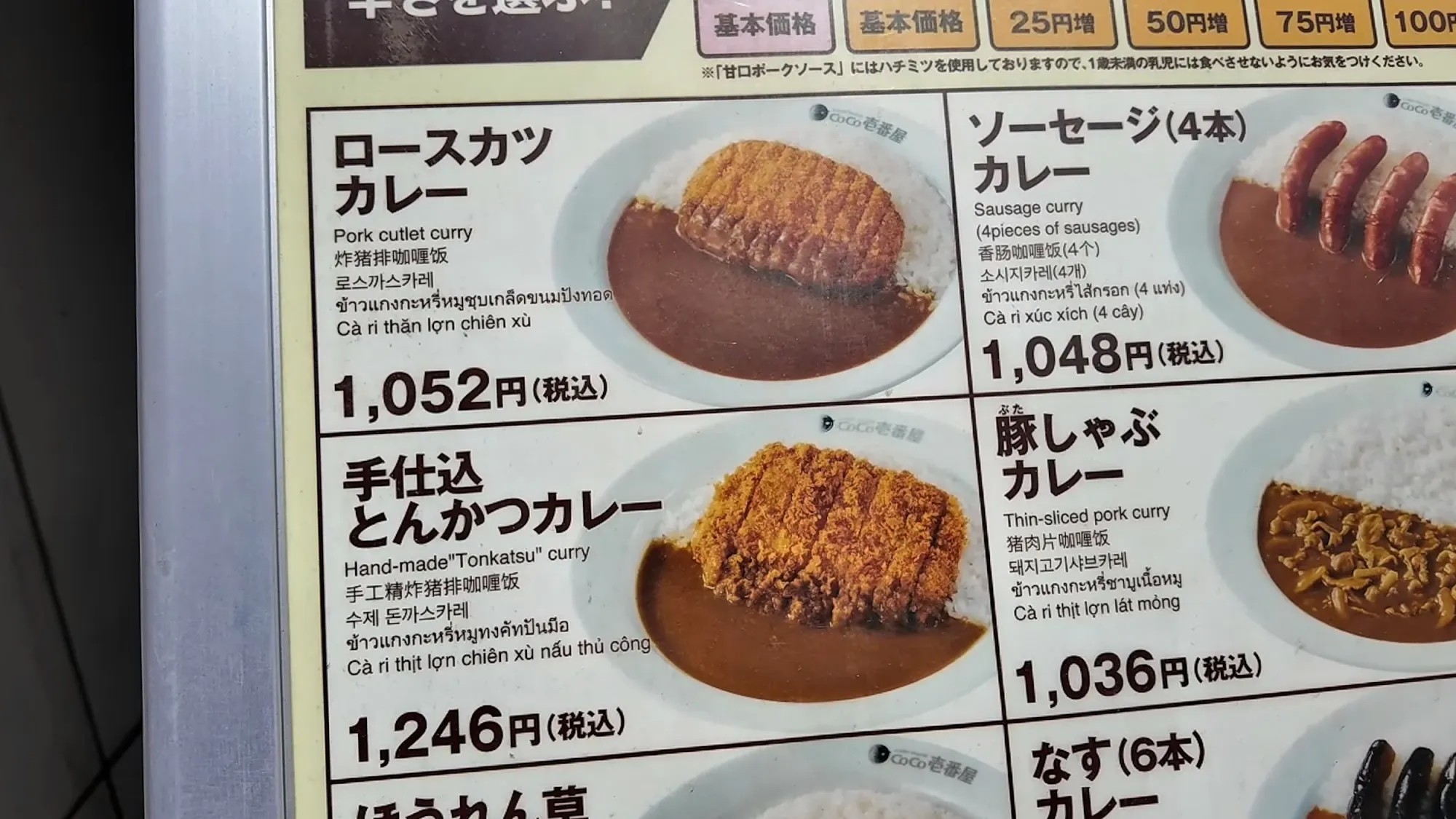 A CoCo Ichibanya menu board in Tokyo showing pork cutlet curry and other curries with prices in yen.