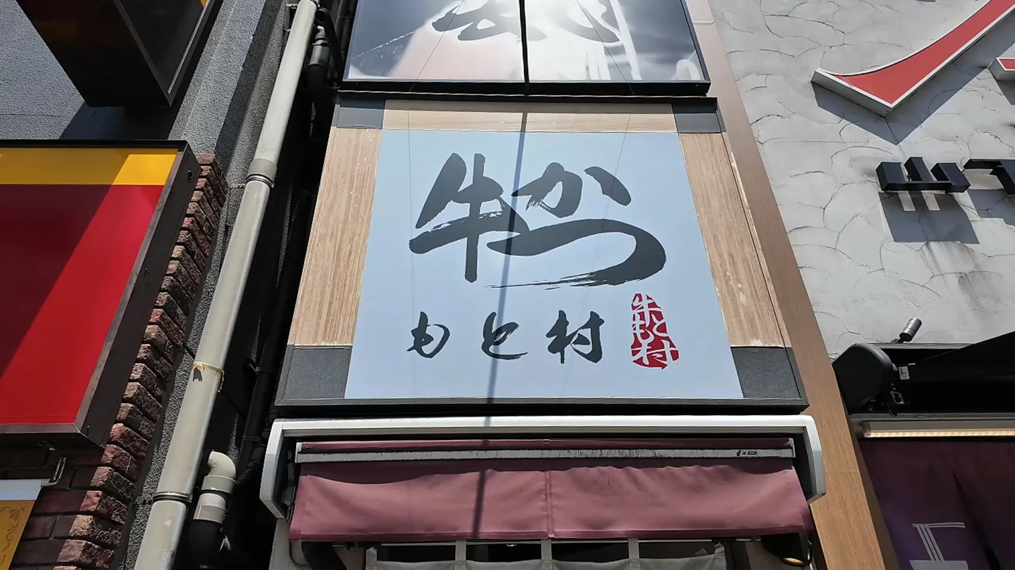 The Gyukatsu Motomura sign over the stairs down to the Shinjuku South Exit branch