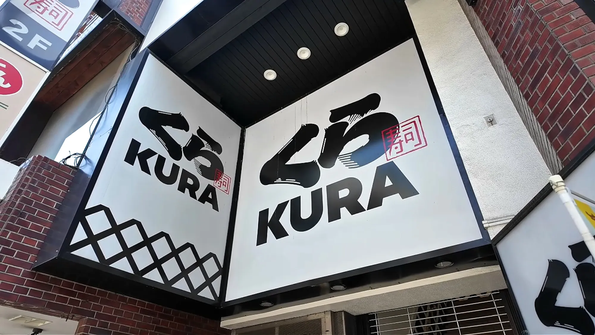 The black and white KURA sign at the entrance of a Kura Sushi in Tokyo