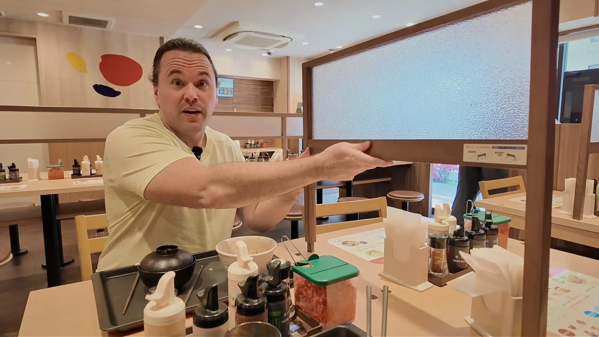 Cream pointing to the adjustable divider between two tables at Matsuya in Tokyo.
