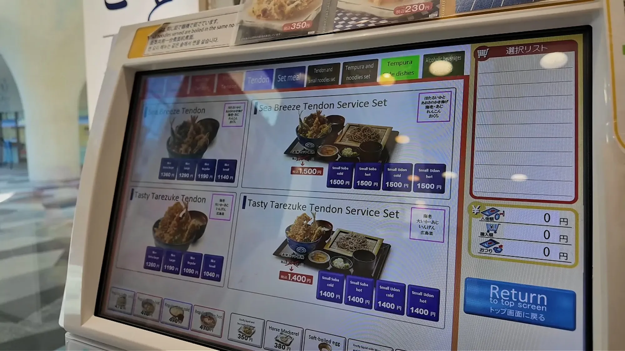 The Tenya kiosk menu in English showing the Sea Breeze Tendon and Tasty Tarezuke Tendon, with a price button for each rice size.