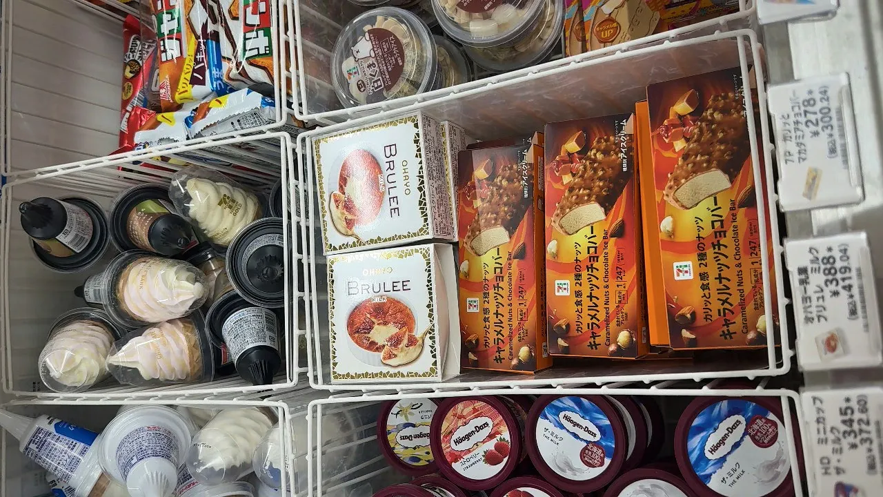 The ice cream freezer at a Tokyo 7-Eleven, with BRULEE boxes, caramel nut bars, and rows of cups and cones in wire baskets.