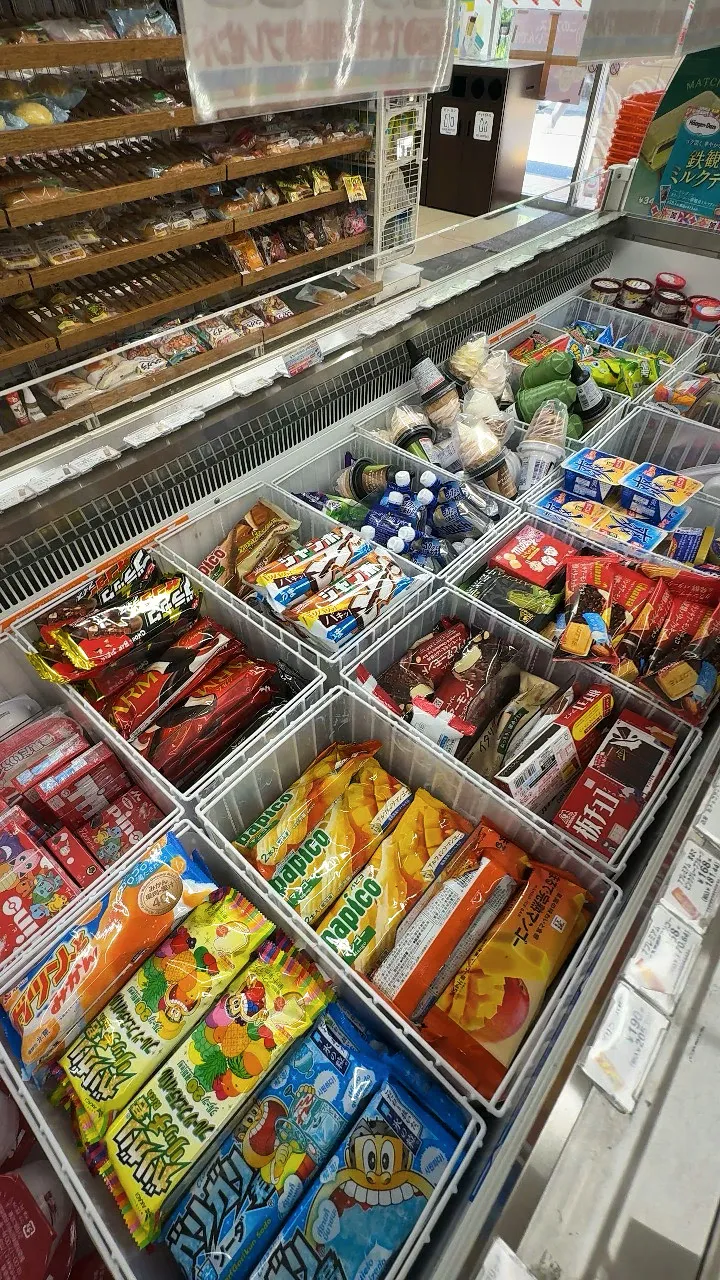 A 7-Eleven ice cream freezer in Tokyo packed with ice cream bars, monaka, and cones in colorful packages.