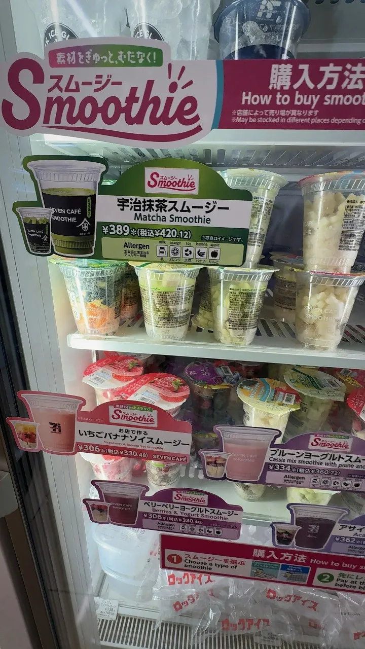 A 7-Eleven freezer case with a Smoothie sign, a how to buy panel, and frozen smoothie cups including the Uji matcha flavor at 389 yen.