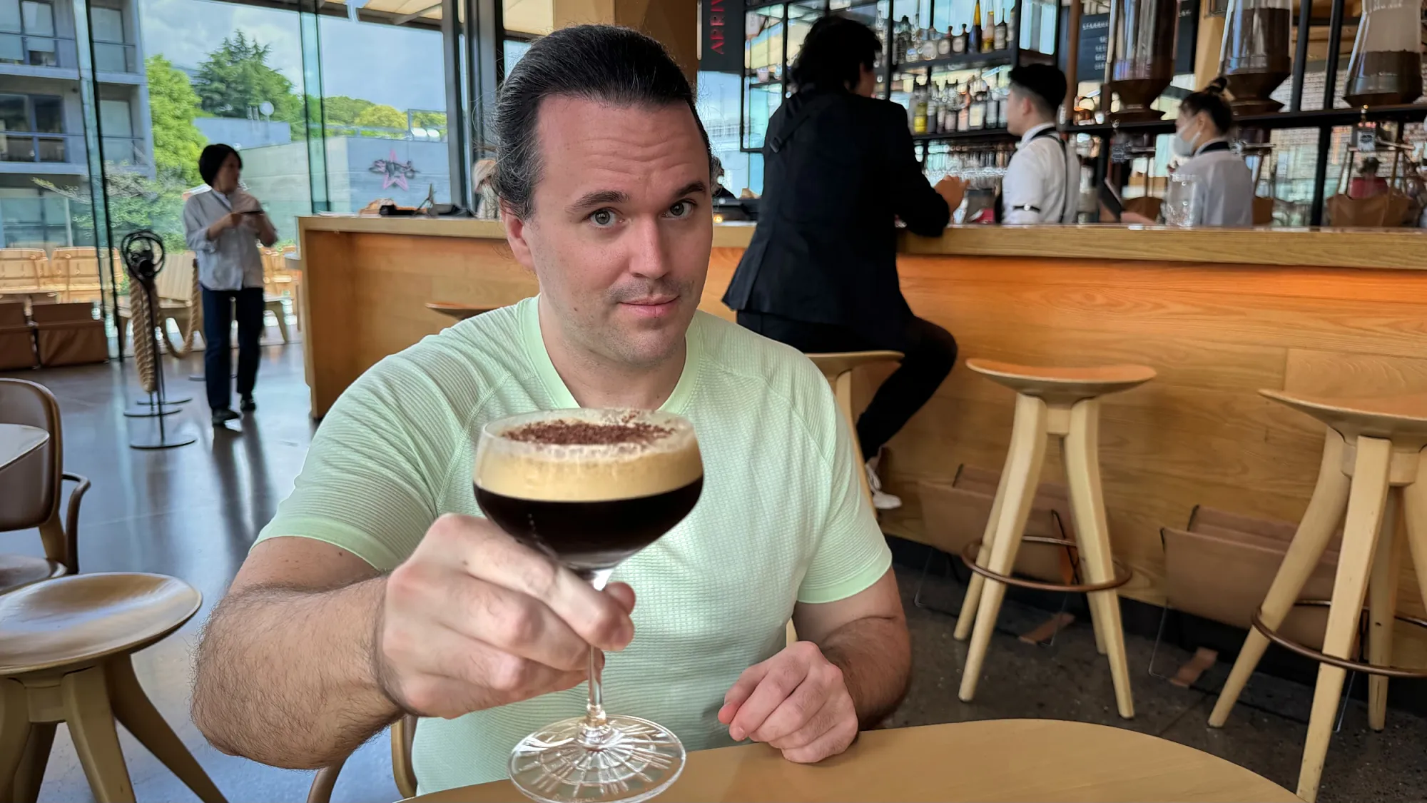 Cream raising a Starbucks Reserve Espresso Martini at a table in the Arriviamo bar, Starbucks Reserve Roastery Tokyo.