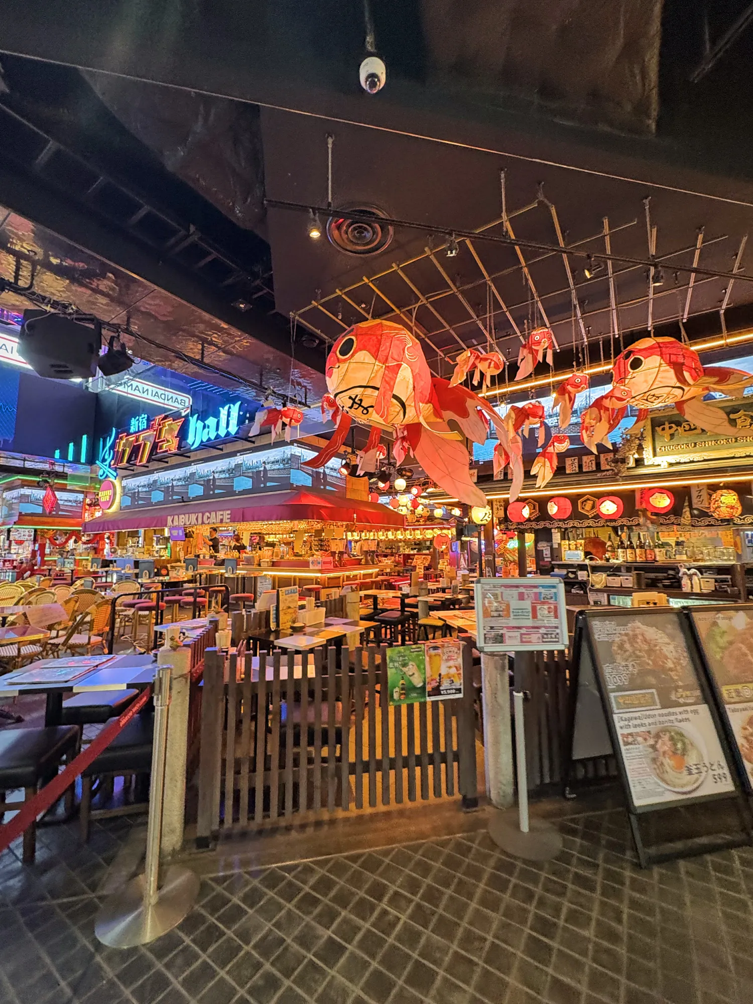 Giant red goldfish lanterns hanging over the tables and food stalls inside Shinjuku Kabuki Hall in Tokyu Kabukicho Tower, Tokyo.