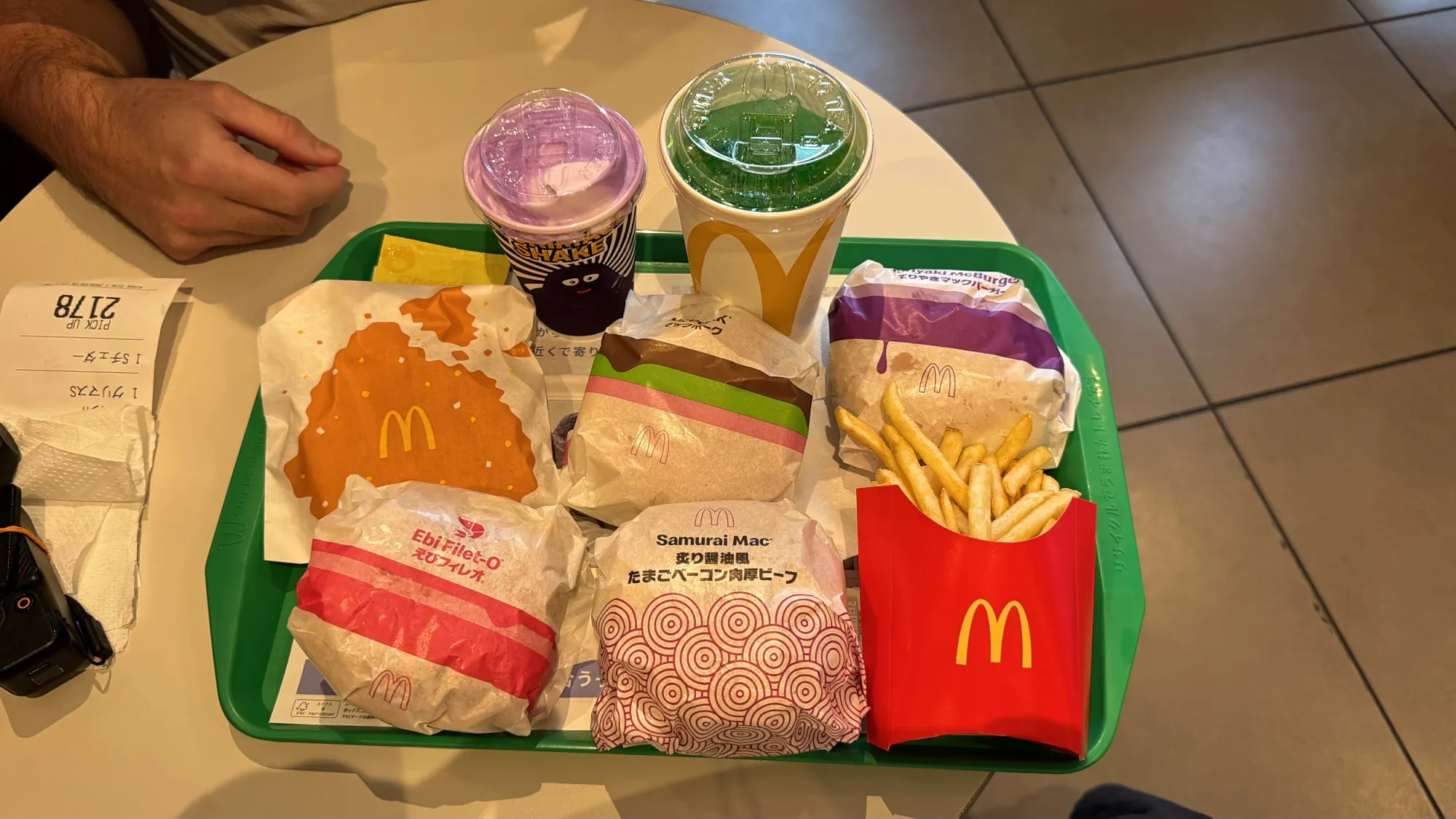 A McDonald's tray in Japan with burgers, fries, a purple Grimace shake, and a green melon soda.