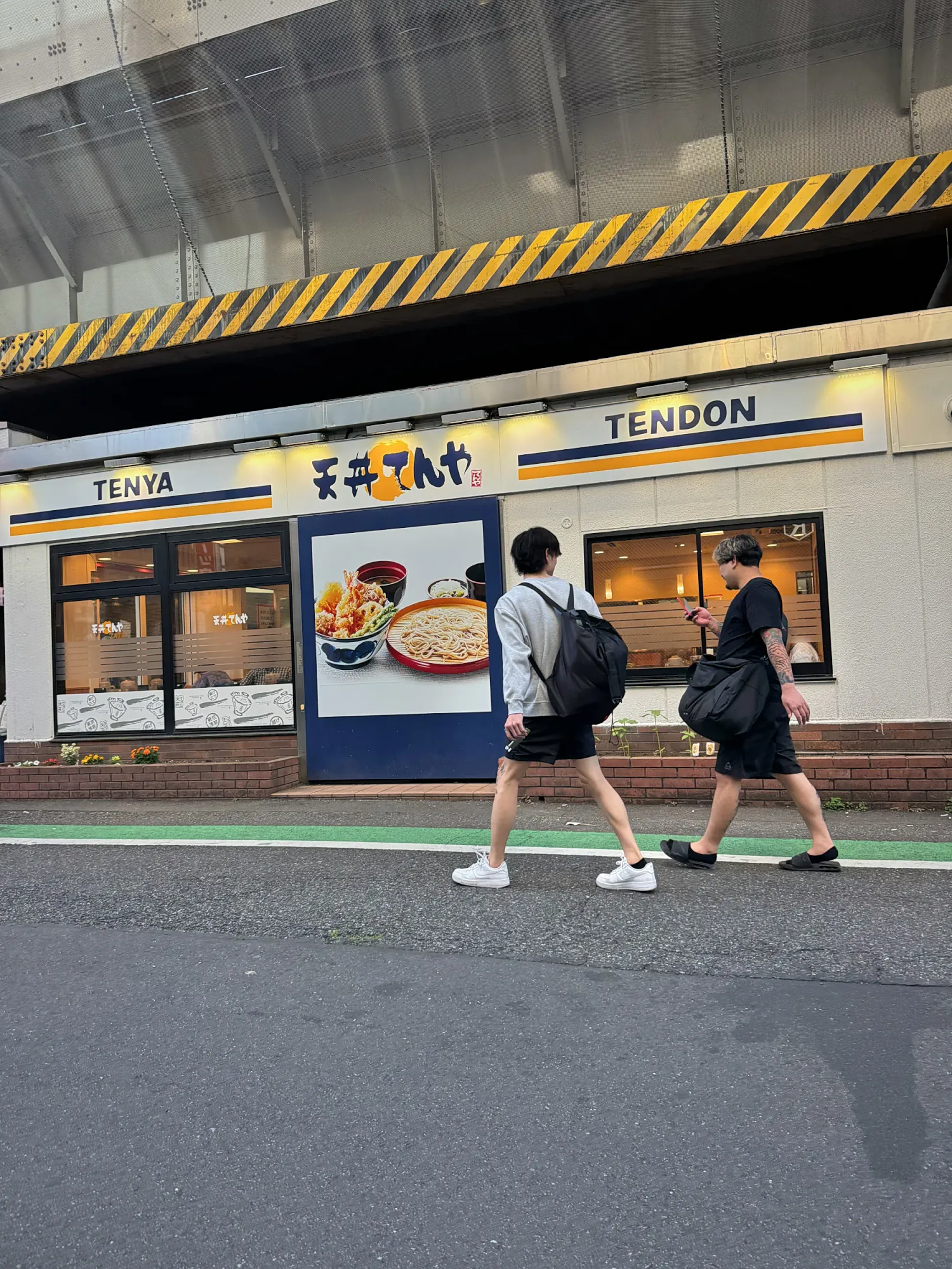 People walking past a Tendon Tenya restaurant on a Tokyo street