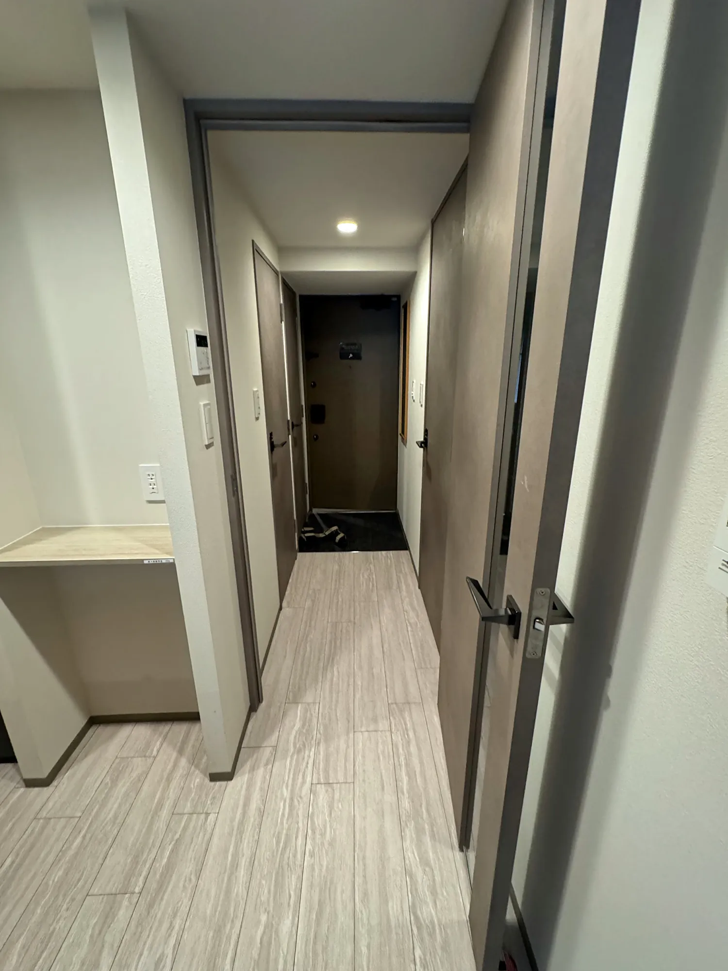The entryway and hallway of a small apartment in Shinjuku, Tokyo, with the front door at the end.