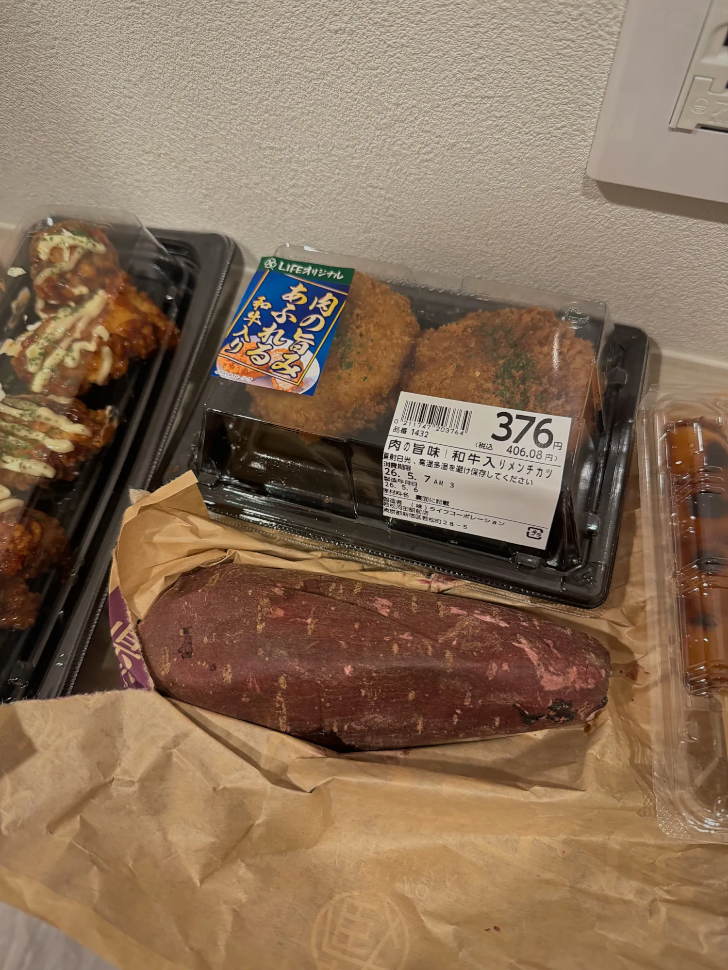 Fried food and a roasted sweet potato from the Life supermarket, still in their packs with price stickers, at our apartment in Shinjuku.