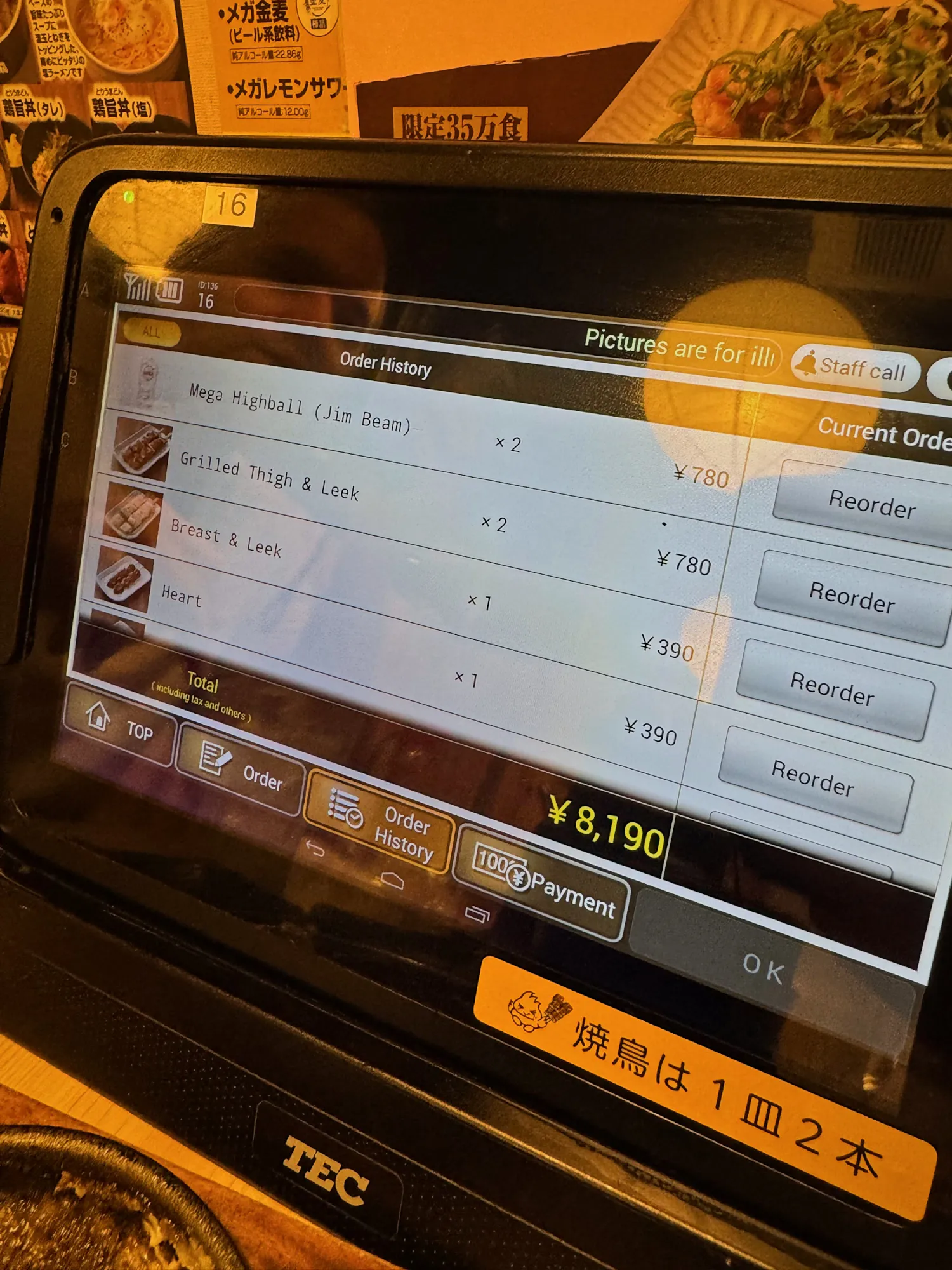 The order history on the table tablet at Torikizoku in Tokyo, in English, listing mega highballs, grilled thigh and leek, breast and leek, and heart skewers at 390 yen per order, with Reorder and Payment buttons.