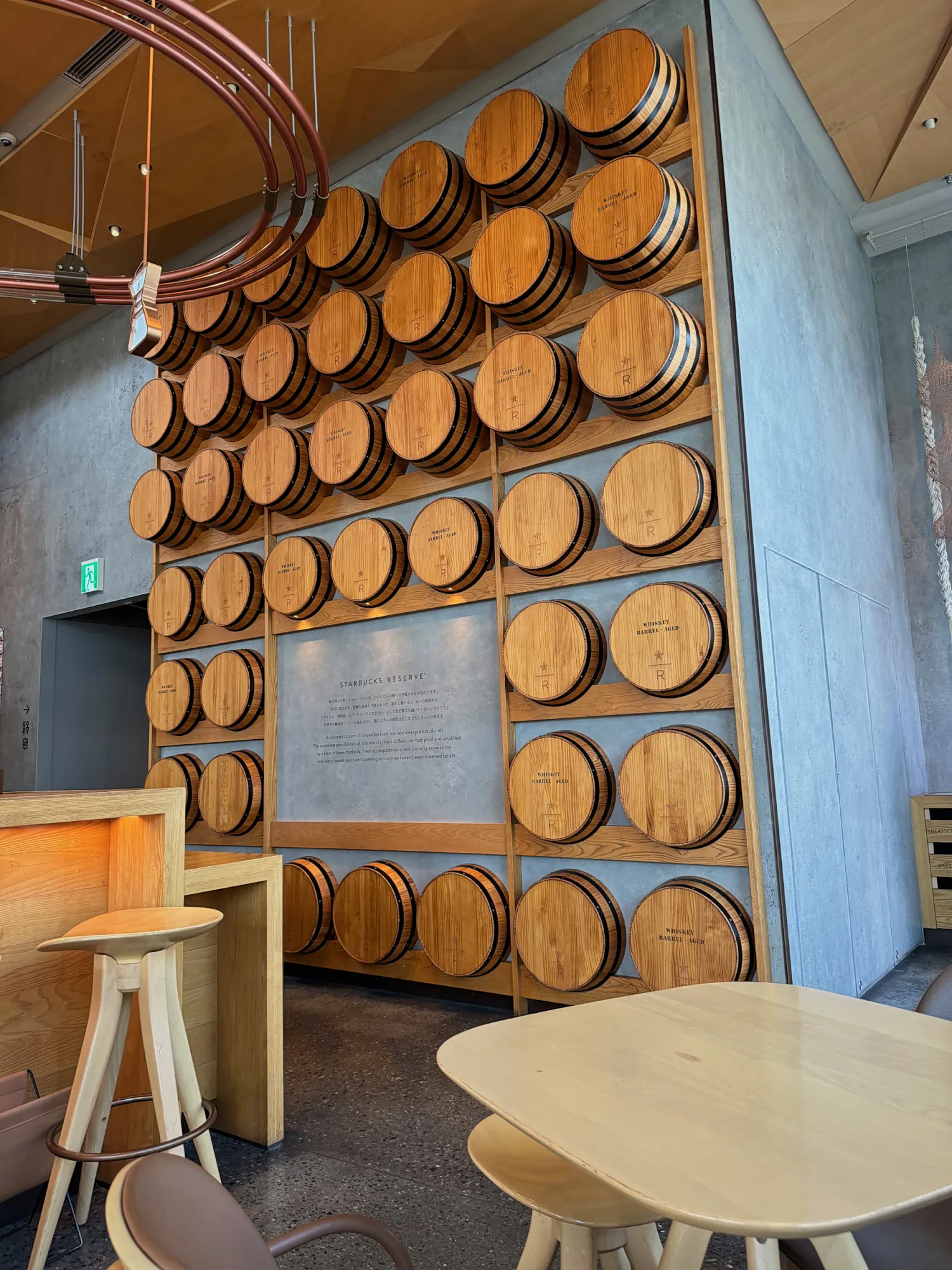 A wall of stacked wooden whiskey barrels on the cocktail floor of Starbucks Reserve Roastery Tokyo.
