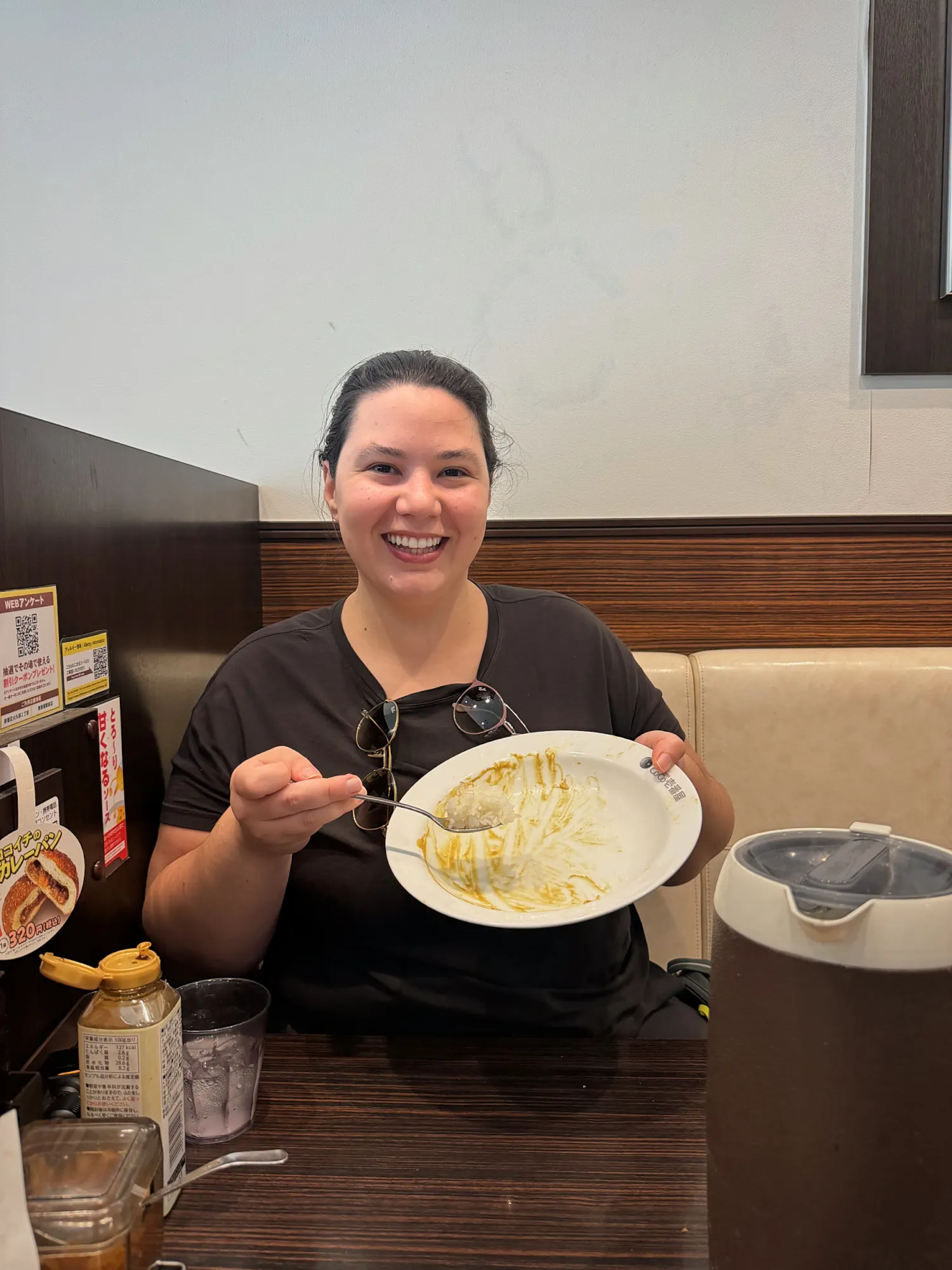 Bernie smiling and holding up a nearly empty curry plate at the end of the meal at CoCo Ichibanya in Shinjuku.