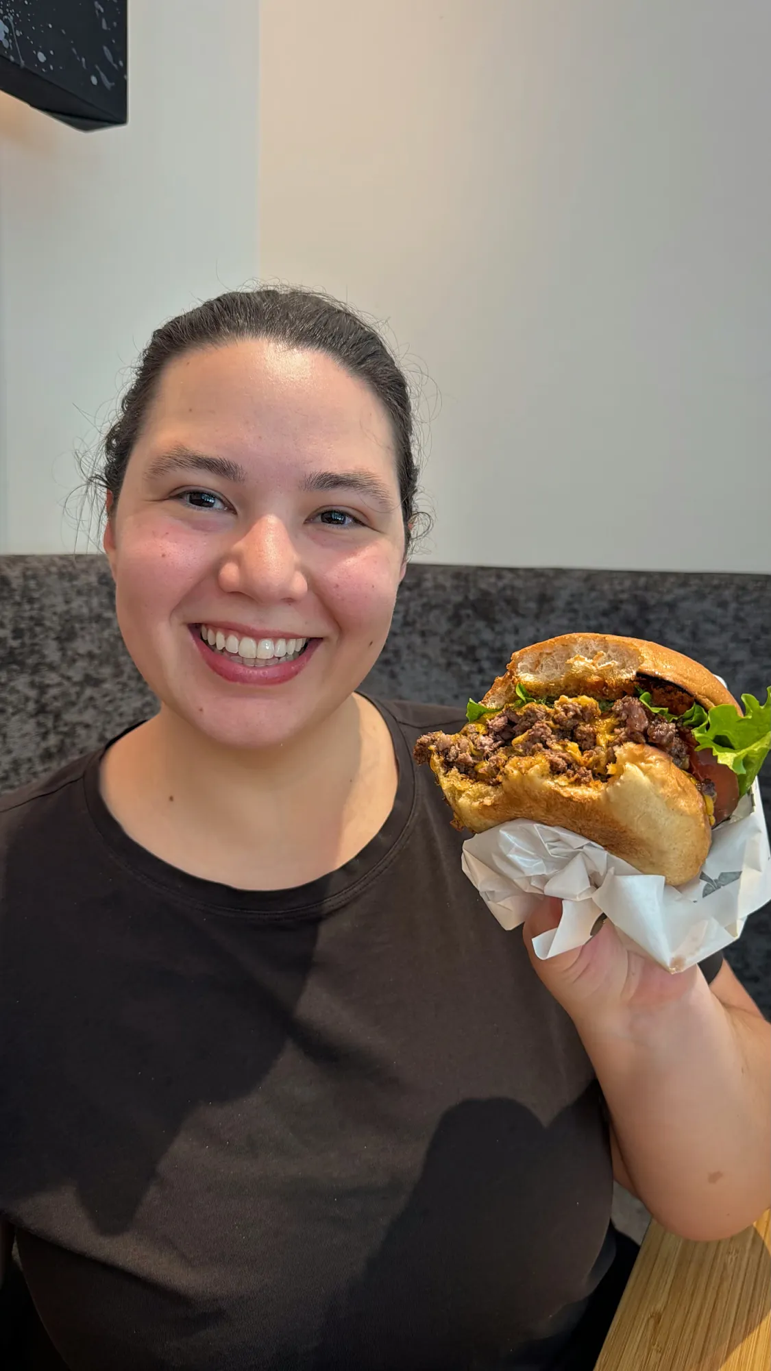 Bernie holding up a Shogun Burger double cheeseburger in its paper wrap