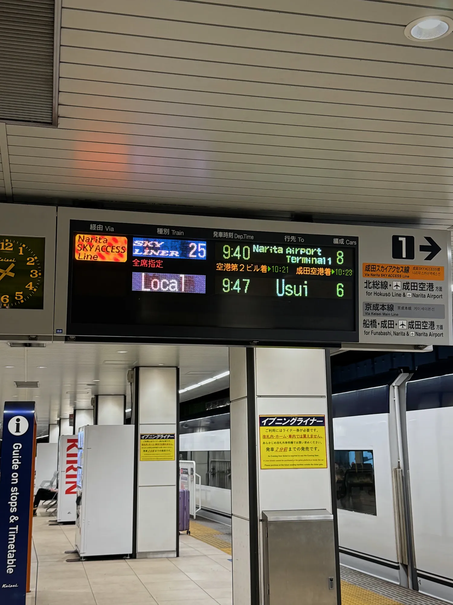 A departure board at Keisei Ueno Station showing the next Skyliner to Narita Airport, with the white Skyliner train waiting at the platform.