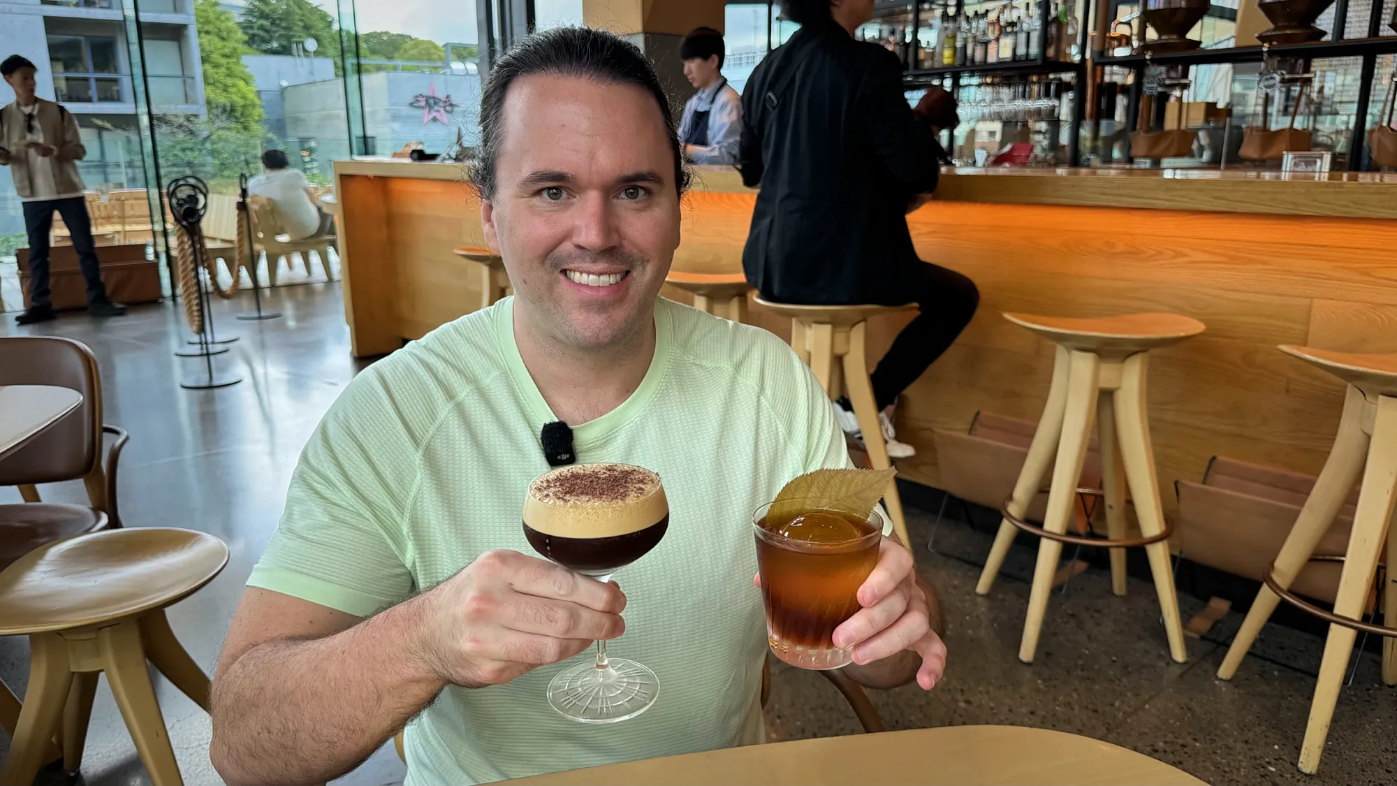 Cream smiling and holding up an Espresso Martini and a New Tokyo Fashion in the Arriviamo bar at Starbucks Reserve Roastery Tokyo.
