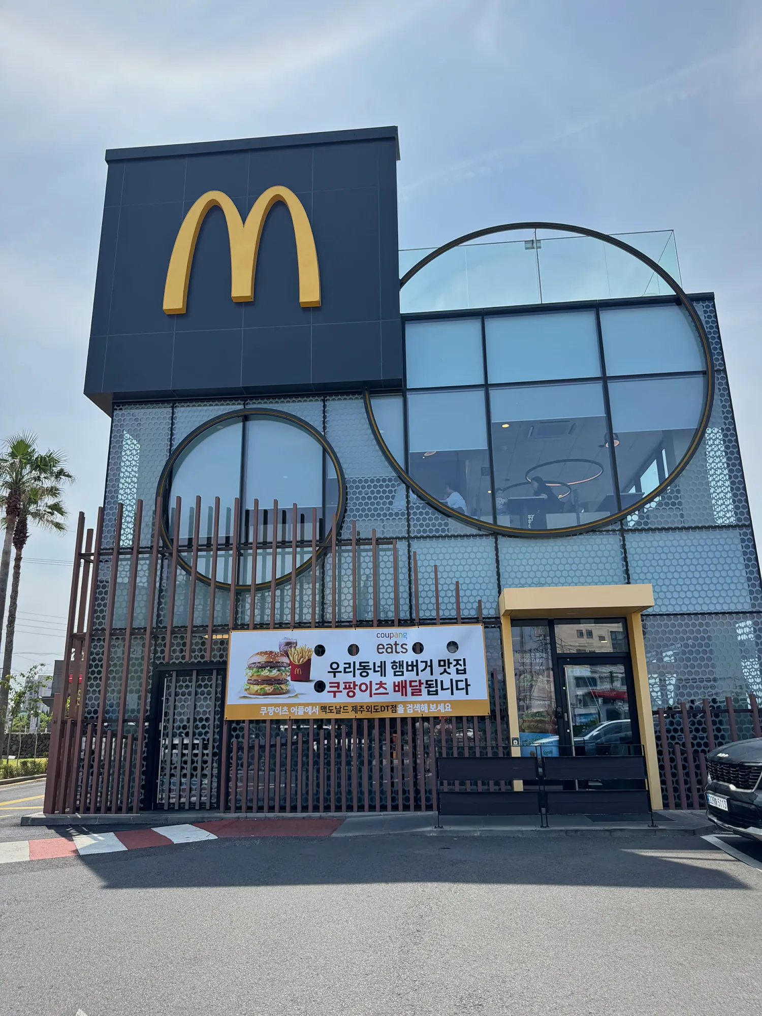 The outside of an I'm restaurant in Almaty, Kazakhstan, a former McDonald's, with cars parked in front.