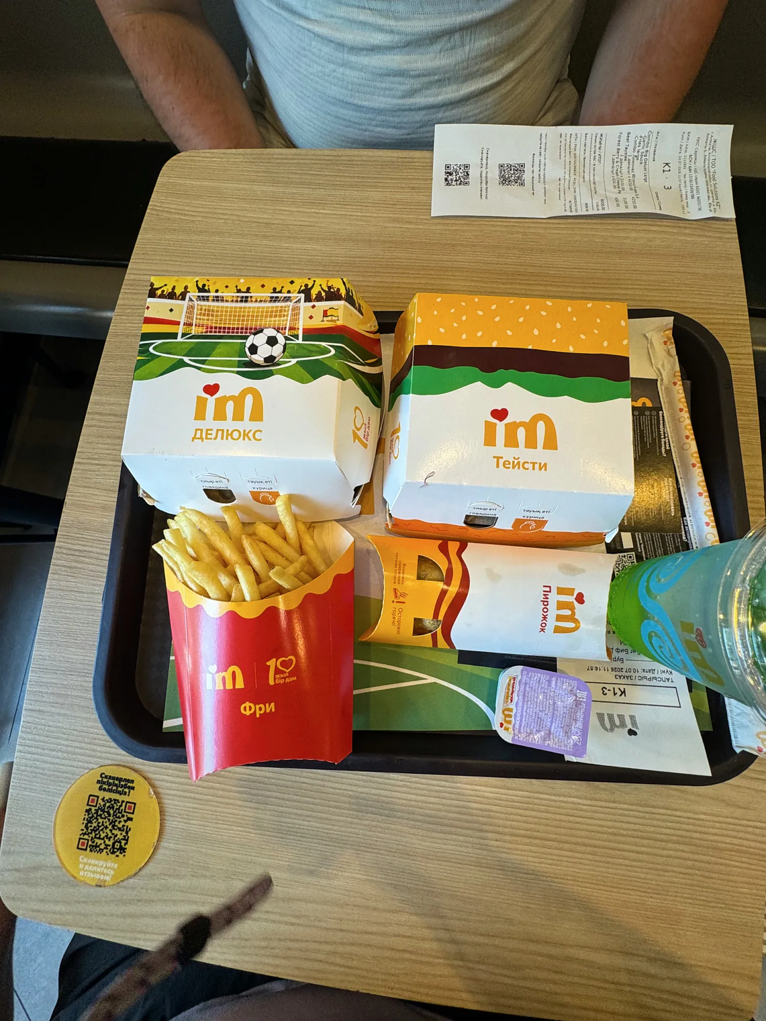 A tray at I'm in Almaty, Kazakhstan, with I'm-branded burger boxes, fries, a dipping sauce, and the paper receipt.
