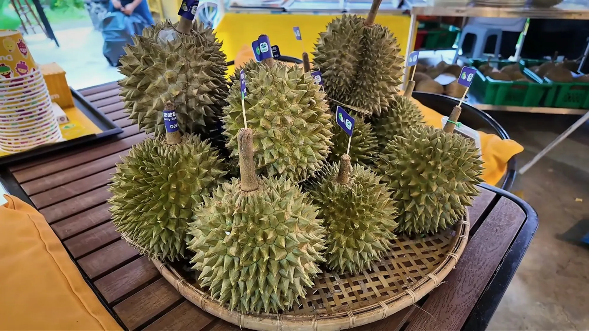 A woven basket piled with whole, spiky green durians at DurianBB Park in Kuala Lumpur.