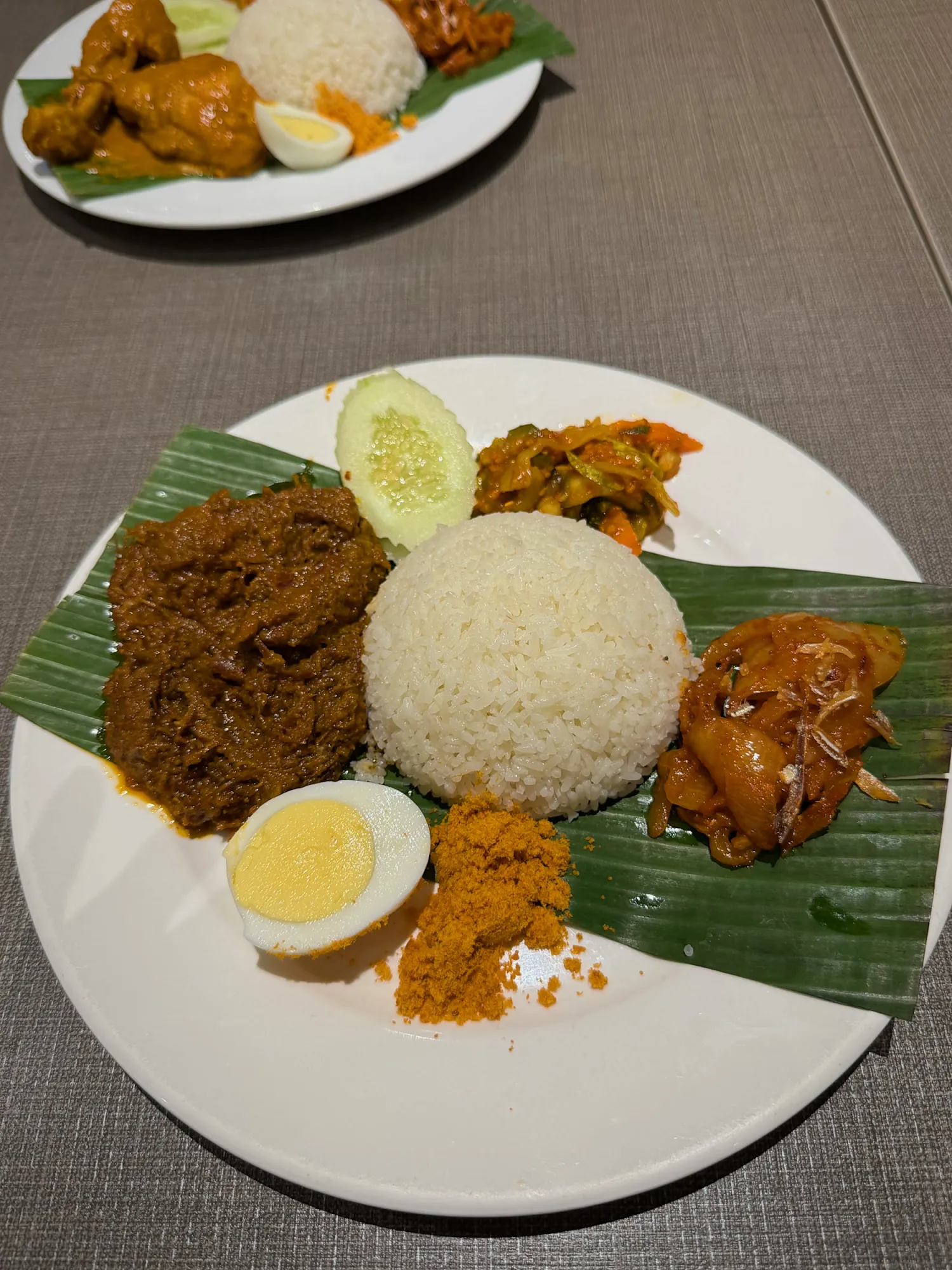 Nasi lemak with beef rendang, sambal, shrimp floss, and an egg on a banana leaf at Madam Kwan's in Kuala Lumpur.