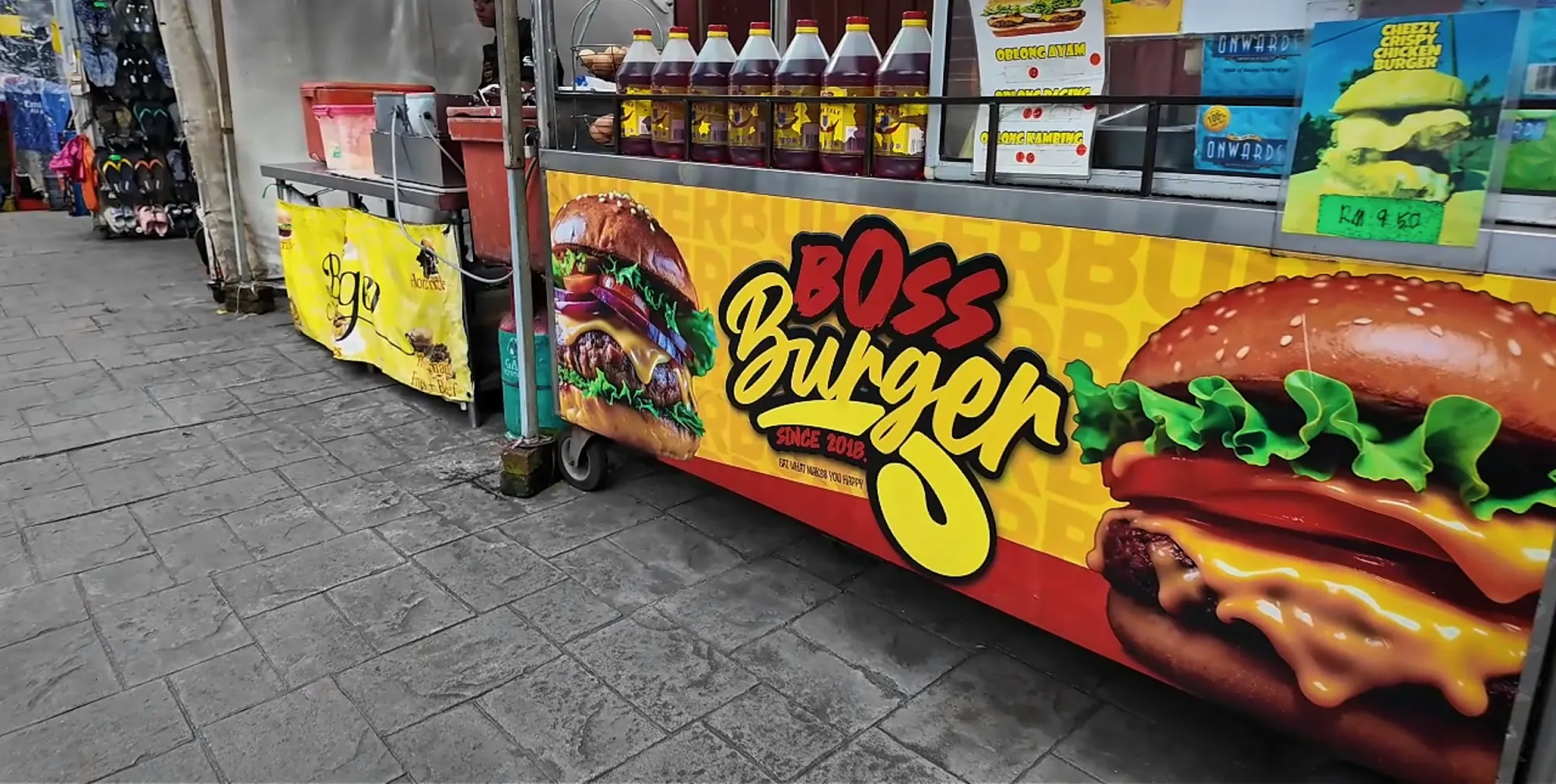 The yellow Boss Burger street cart with its giant burger artwork on Jalan Alor, Kuala Lumpur