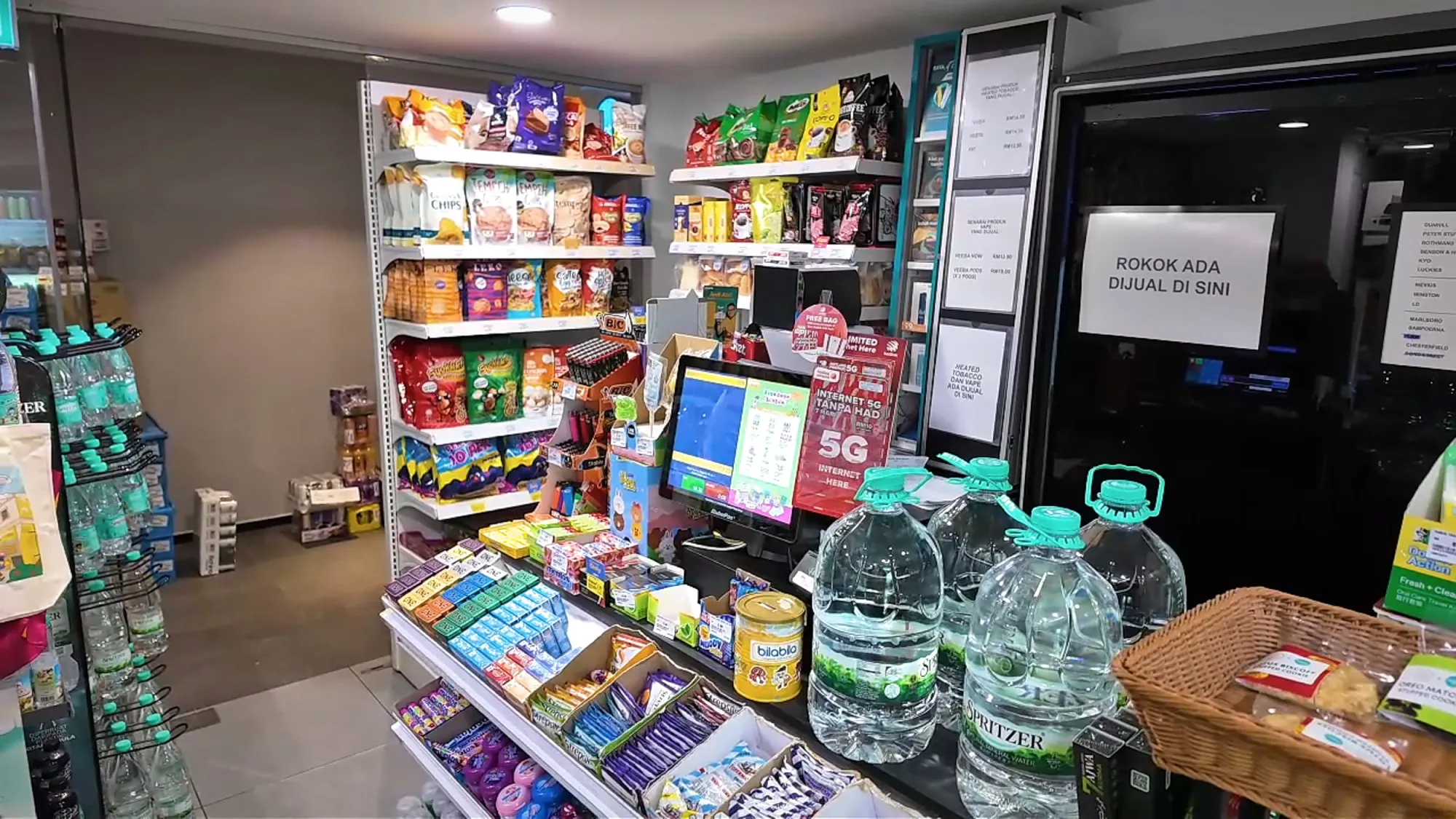 The small convenience store inside Ceylonz Suites, with shelves of snacks, drinks, and big bottles of water by the counter.
