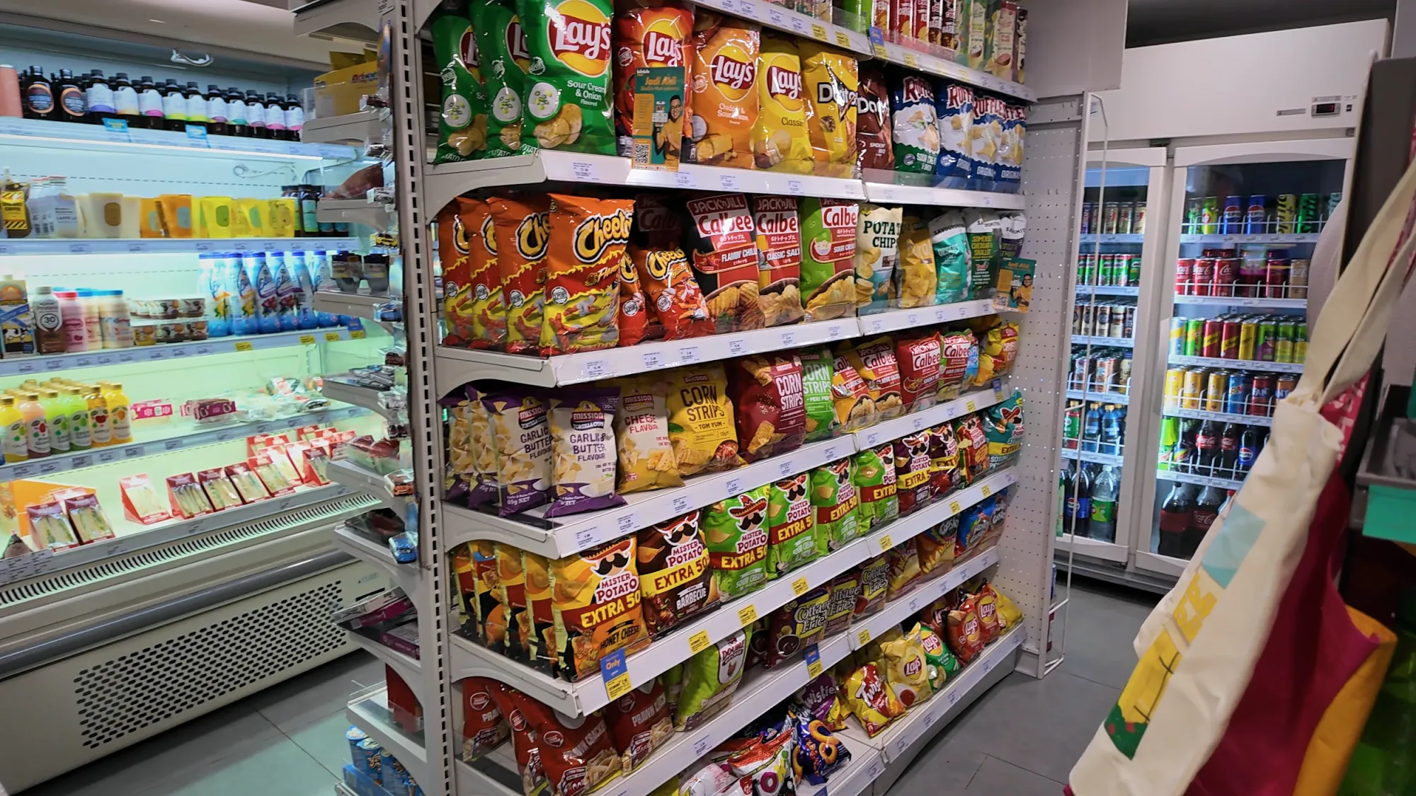 Shelves of chips, snacks, and fridges of drinks in the convenience store at Ceylonz Suites.