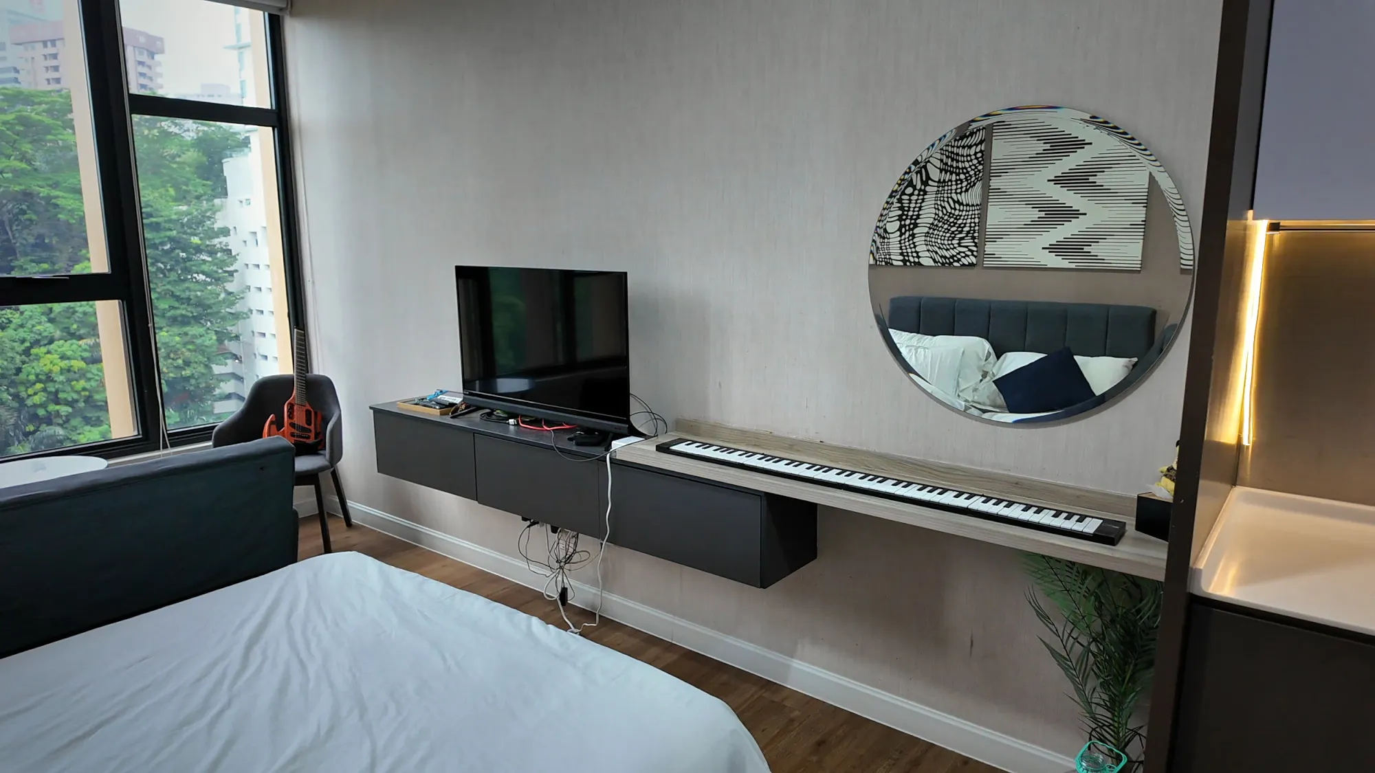 The kitchen counter and desk area in our studio at Ceylonz Suites, with a round mirror and a small plant.