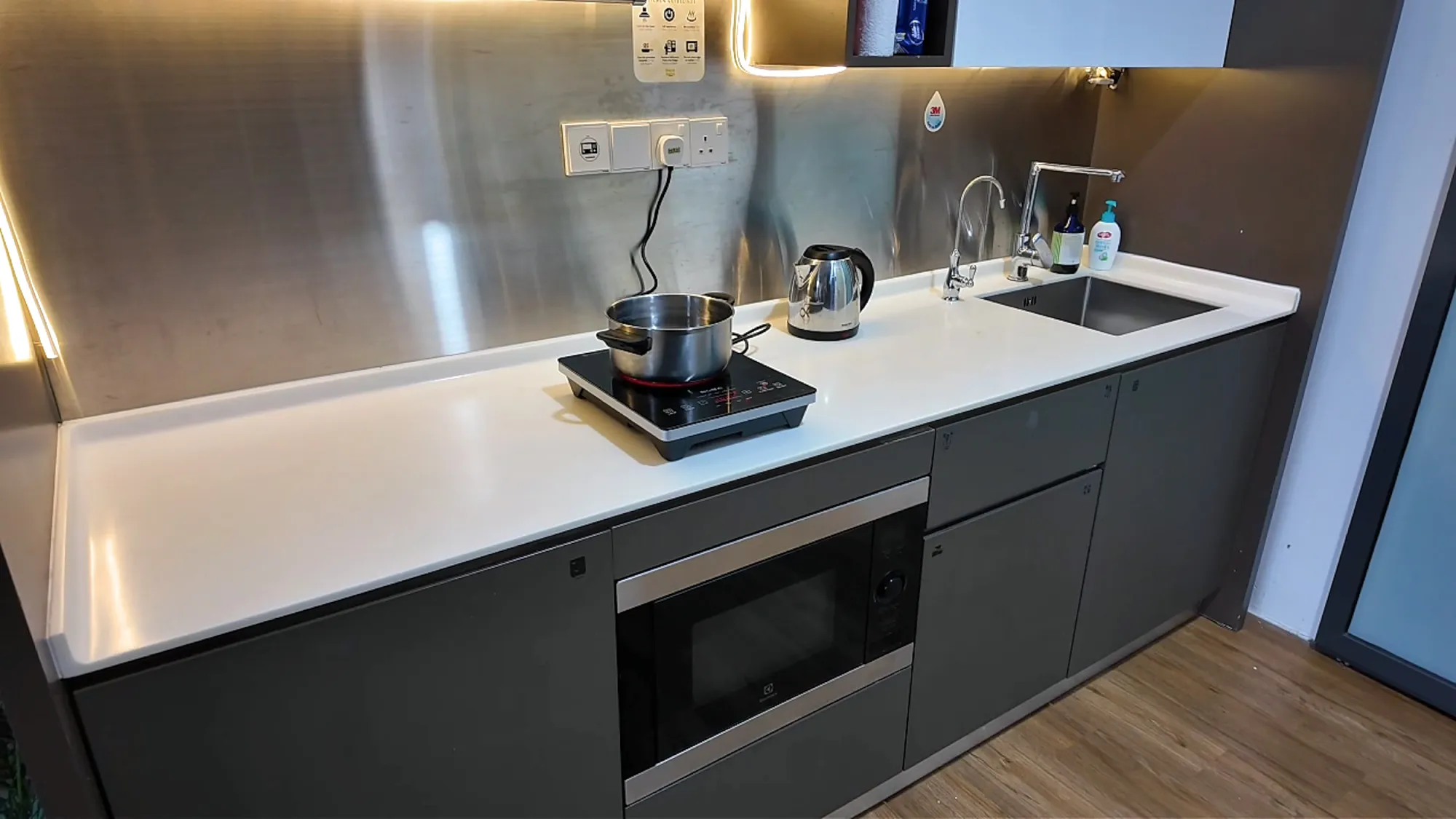 The small kitchen in our studio at Ceylonz Suites, with an induction hob, a kettle, a sink, and a built-in microwave.