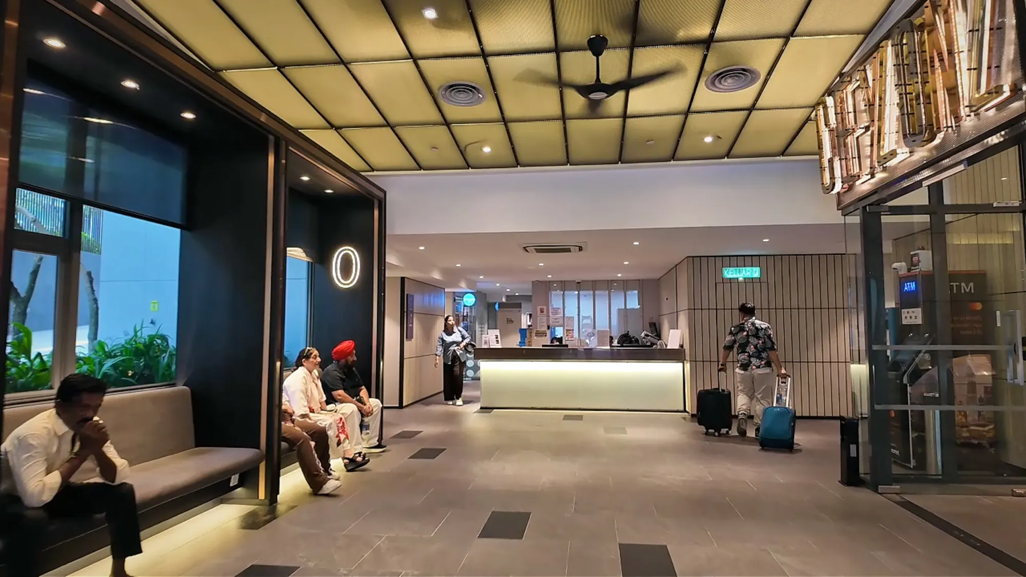 The reception lobby at Ceylonz Suites in Kuala Lumpur, with the front counter at the back and benches along the side.