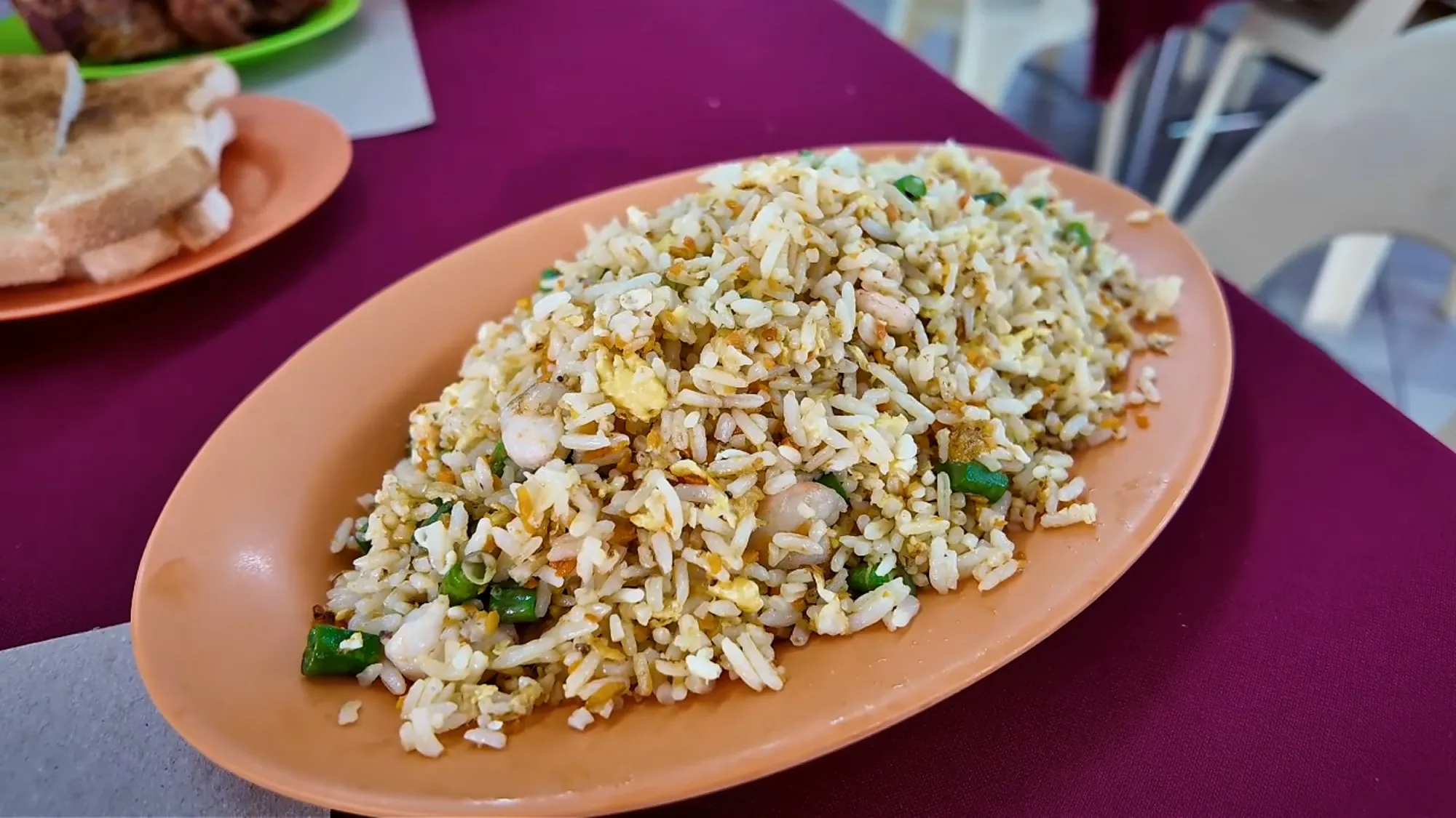 A large oval plate of fried rice with egg, shrimp, and spring onion at Restoran Fatty Crab, Petaling Jaya.