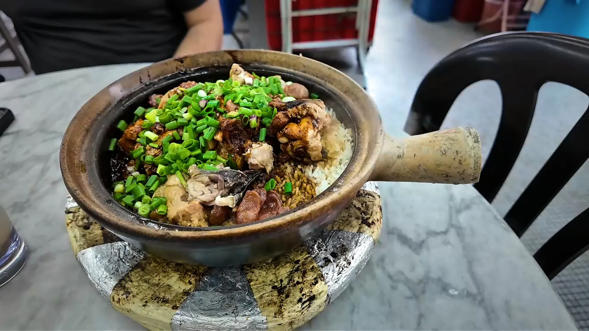 A claypot of rice with chicken, Chinese sausage, and spring onions at 168 Claypot Chicken Rice in Pudu