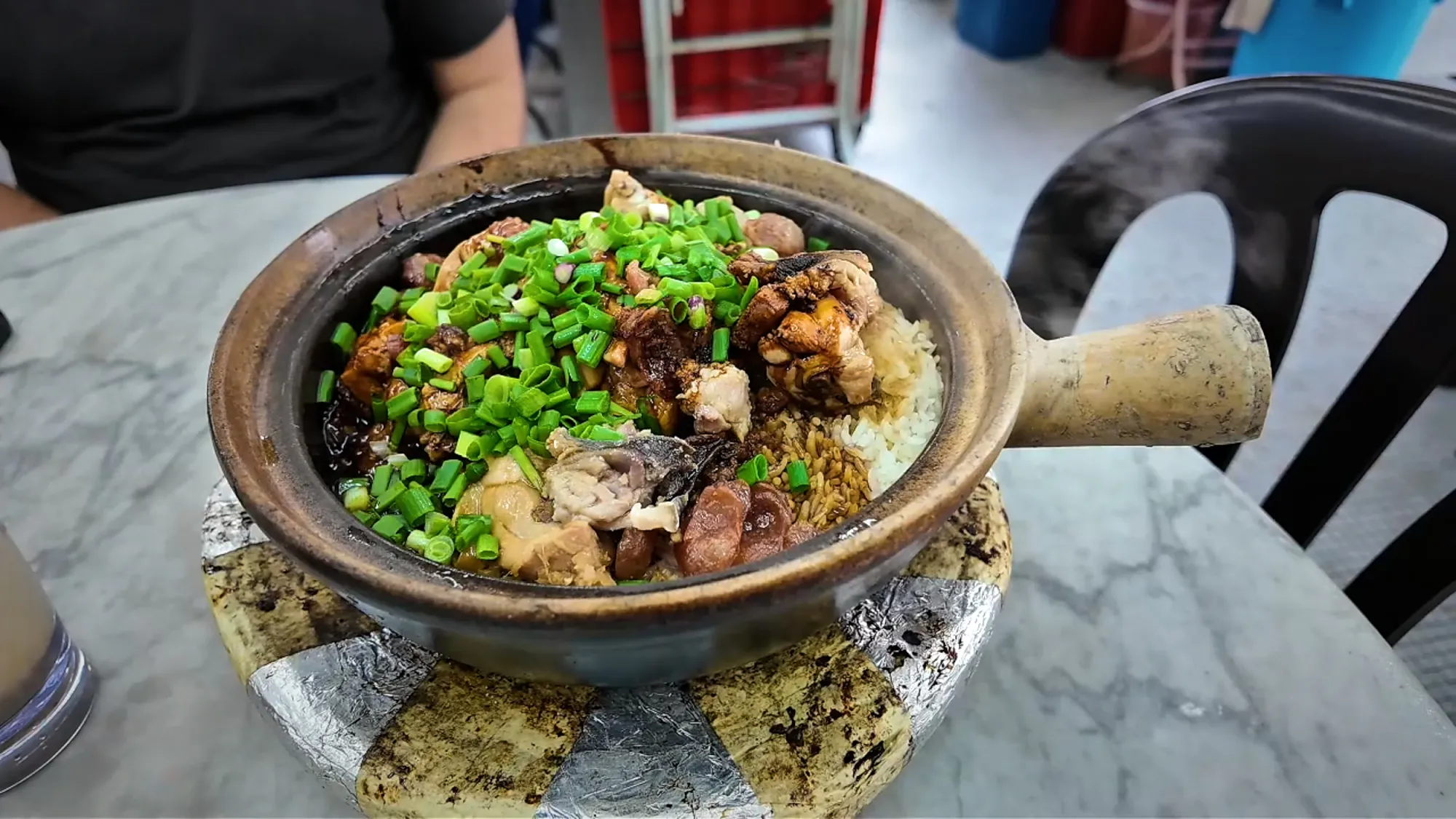 Large pot of claypot chicken rice and greens at 168 Claypot Chicken Rice in Pudu, Kuala Lumpur.