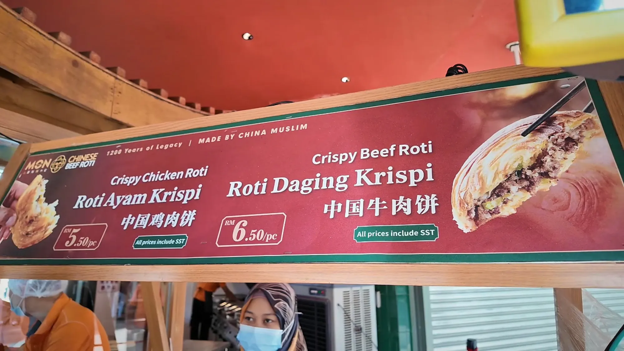 The Mon Chinese Beef Roti menu board listing the crispy chicken roti at RM5.50 and the crispy beef roti at RM6.50.
