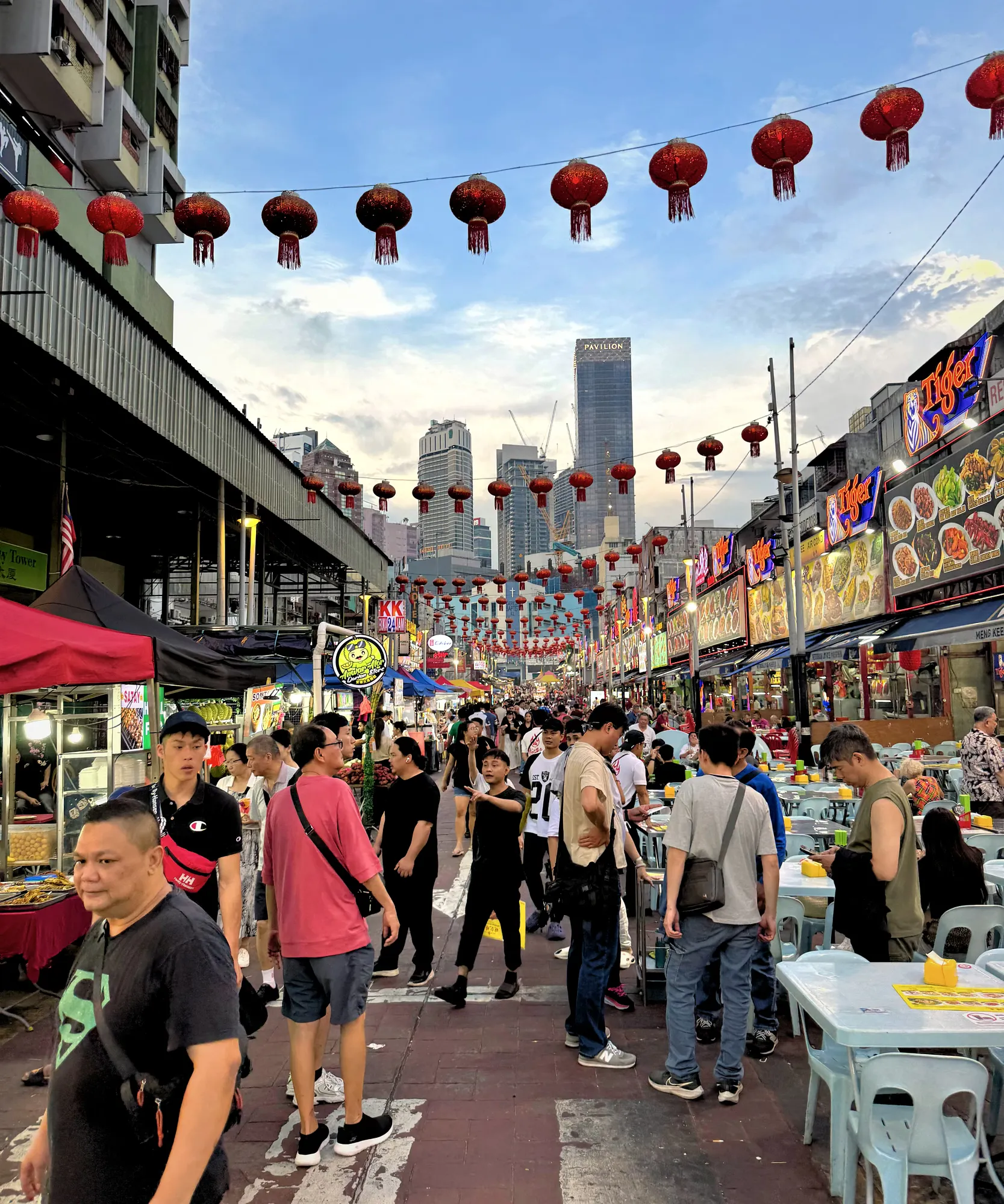 Evening crowds walking down Jalan Alor food street under red lanterns in Bukit Bintang, Kuala Lumpur.