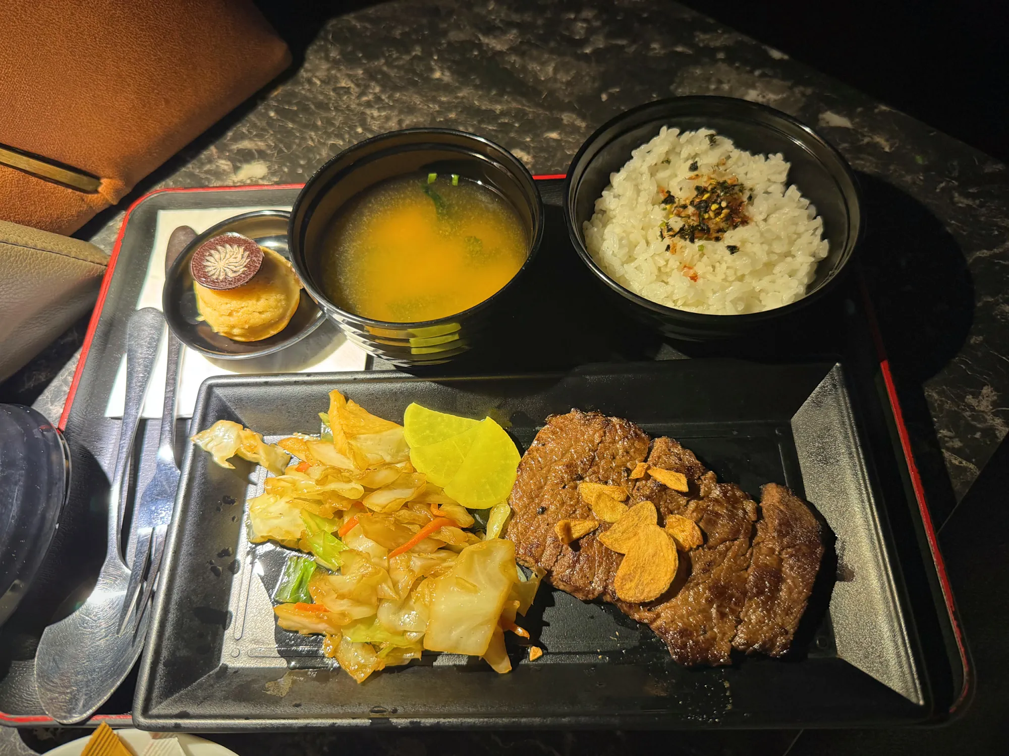 A beef steak set with miso soup, rice, vegetables, and a small dessert, served on a tray in a Getha Lux Suite at Aurum Theatre, Kuala Lumpur.