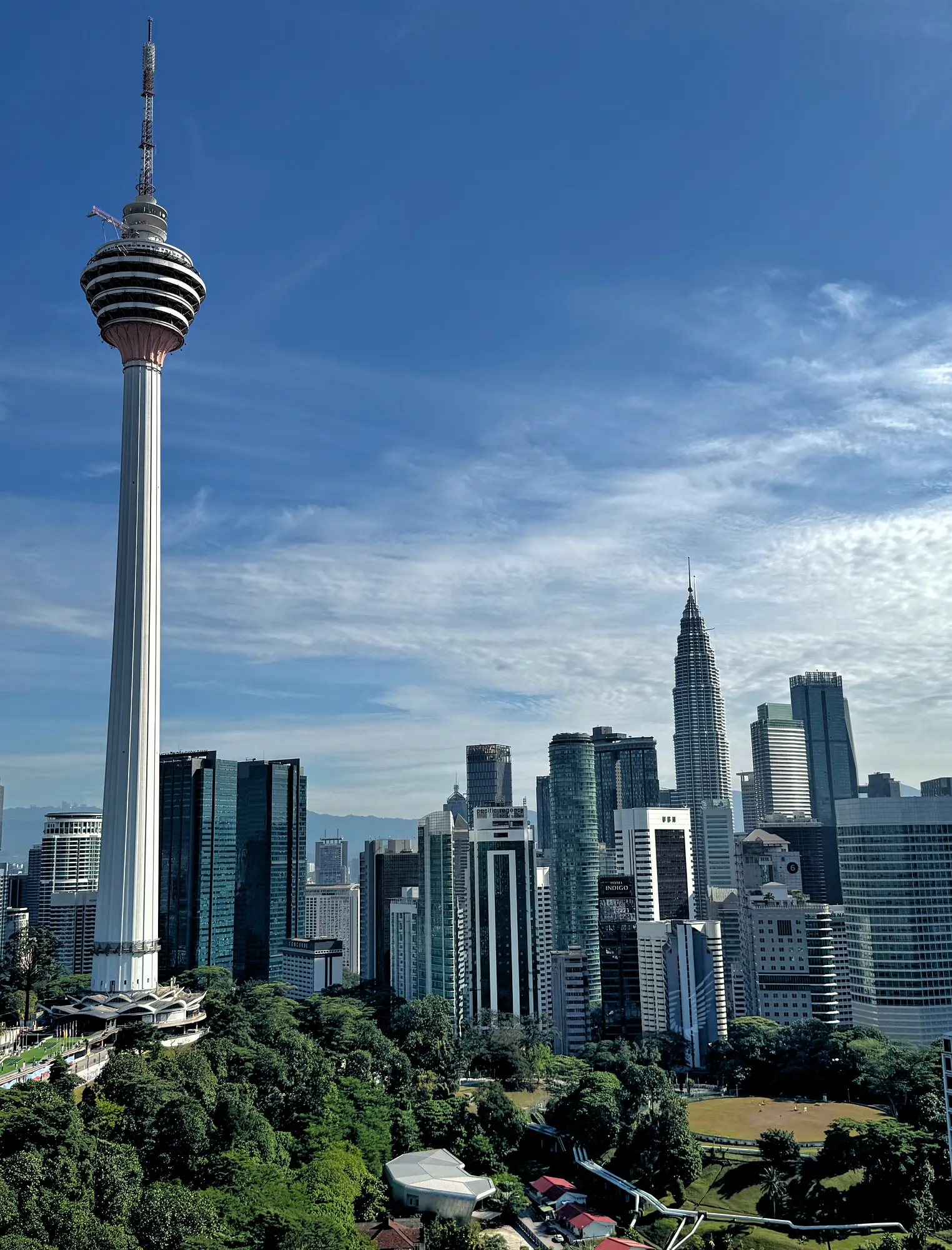 The KL Tower and the Petronas Twin Towers rising above the green canopy of KL Forest Eco Park in central Kuala Lumpur.