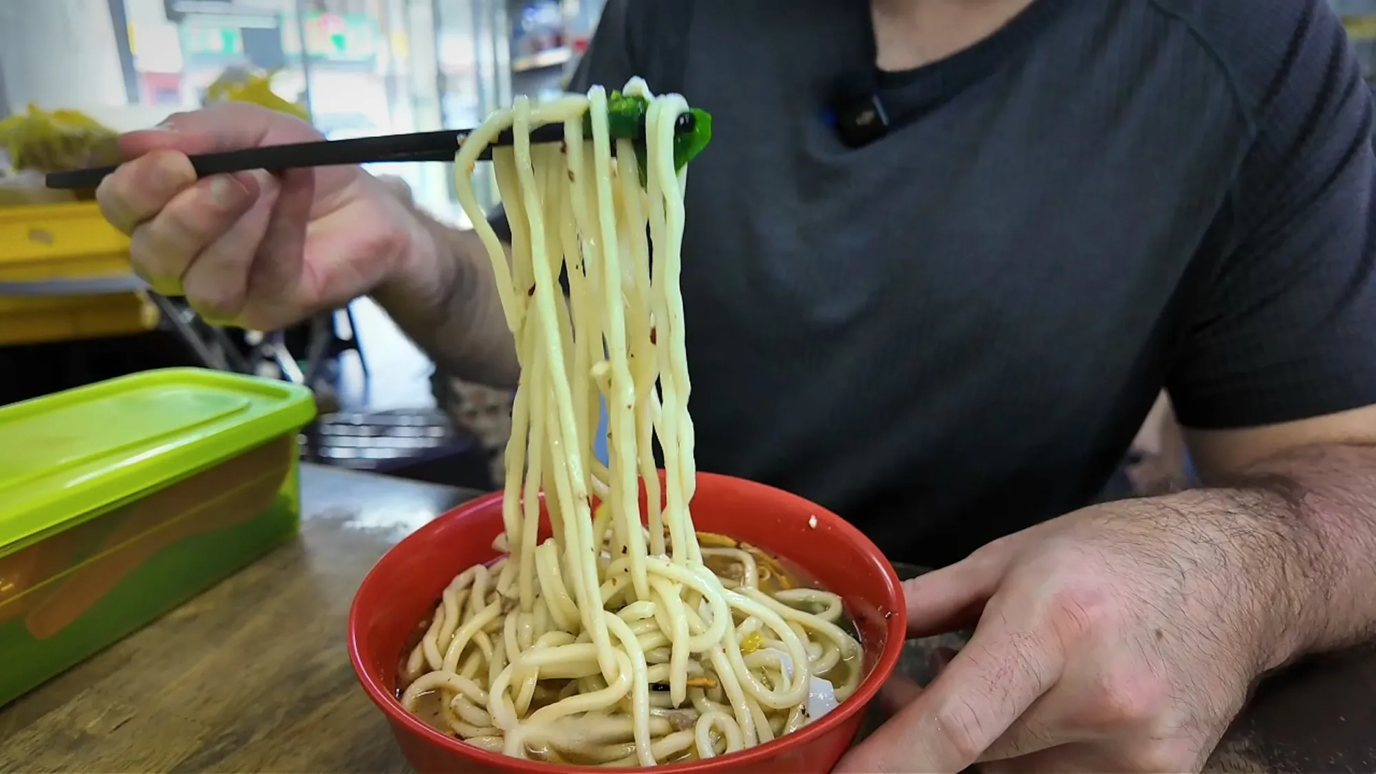Lifting pale pan mee noodles out of the broth of a soup chili pan mee at Kin Kin, Kuala Lumpur.